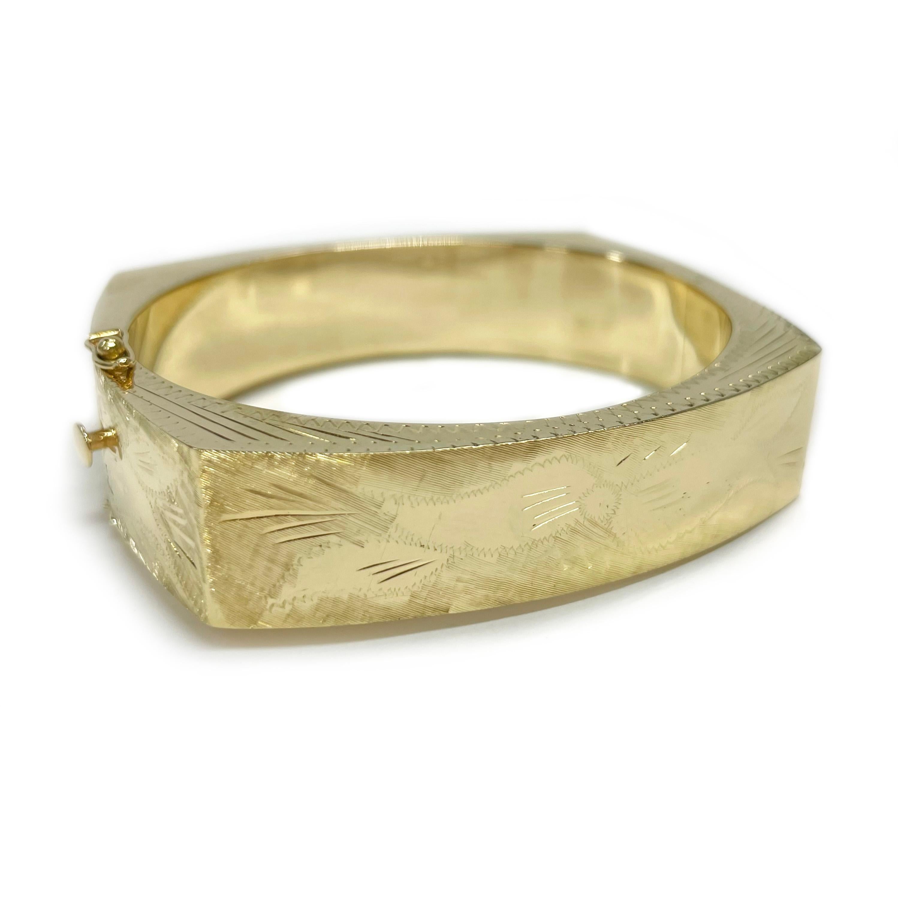 14 Karat Yellow Gold Engraved Diamond-Cut Bangle Bracelet. The hollow bracelet features diamond-cut accents with a hand engraved bow, leaf, and zig-zag designs. The inside of the bangle has a smooth shiny finish while the outside has hand engraving