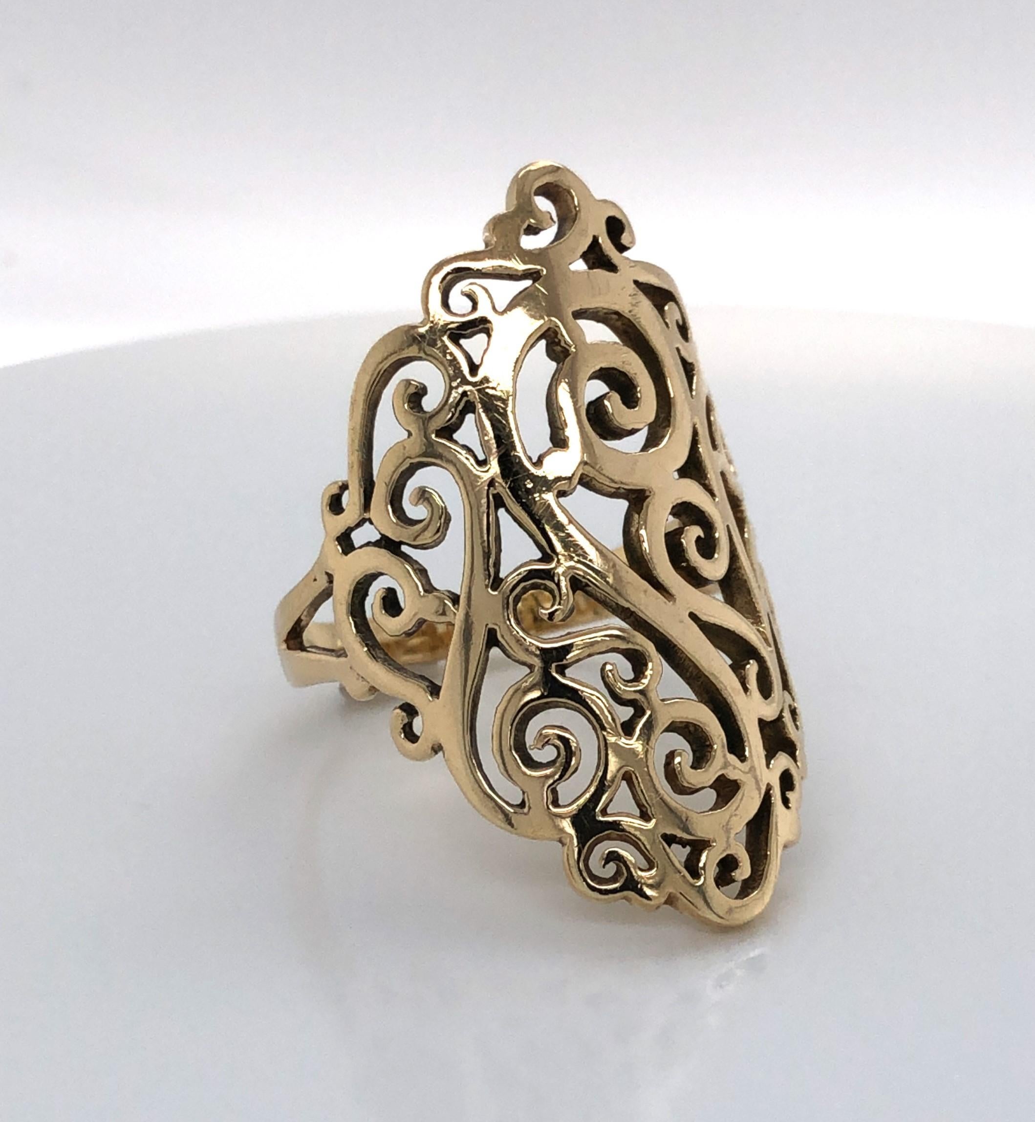 An intricate pierced scroll pattern in a marquise shape creates this artful cocktail ring in fourteen 14K yellow gold.  The shield  style ring measures 1-7/8 long by 7/8 inch wide and is stamped 
stamped 14K. In ring size 10-3/4 and is resizable.