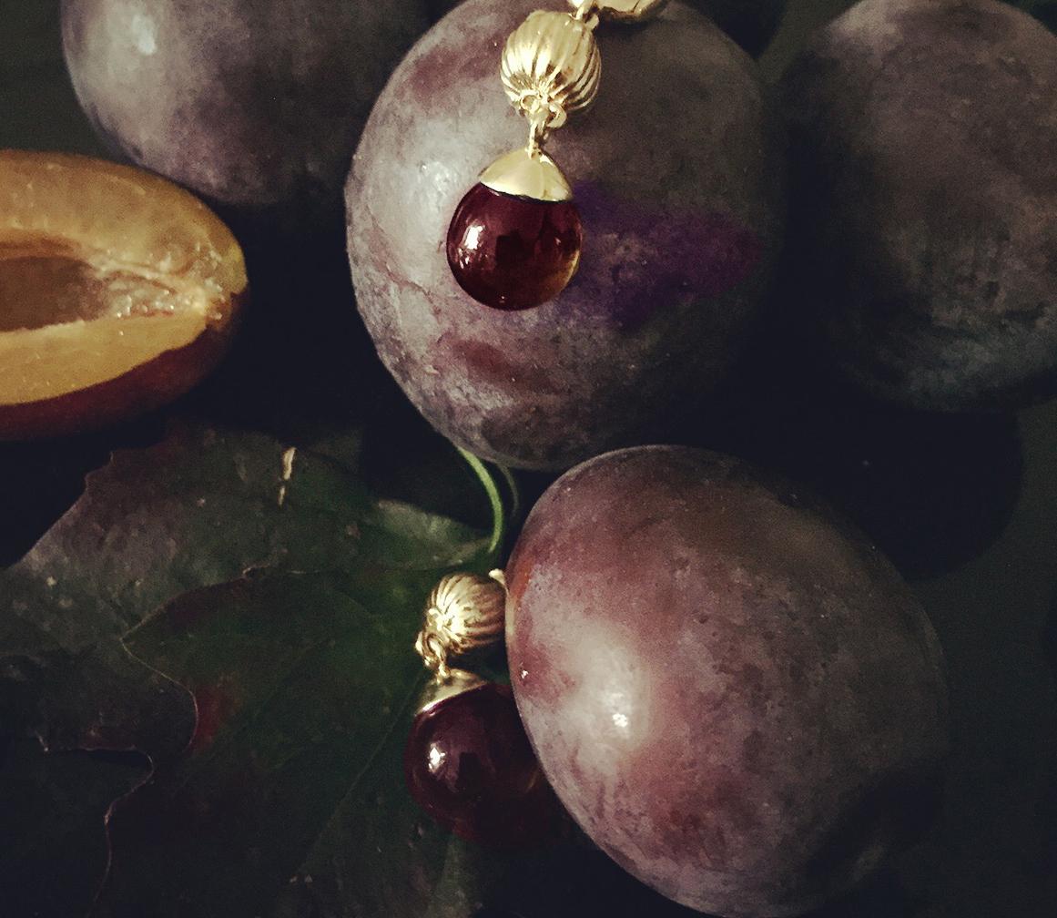 Este collar colgante Fig de oro amarillo de 14 quilates presenta una gema de granate natural cabujón abierta a la luz. La colección apareció anteriormente en Vogue UA.

La artista, Polya Medvedeva, se inspiró para crear una colección de joyas con su