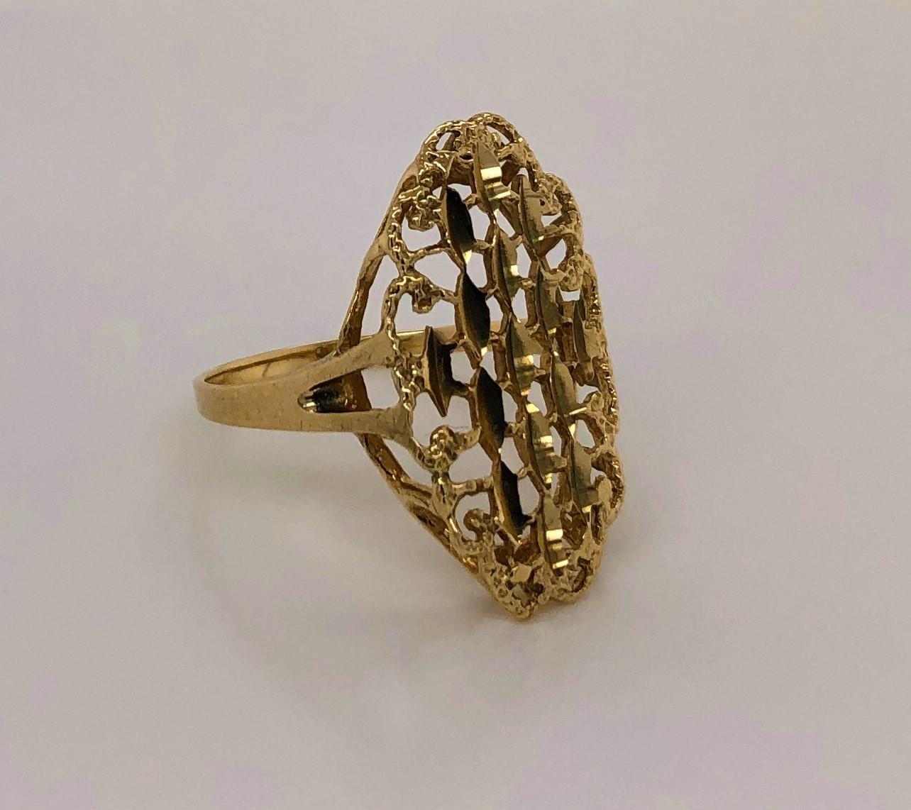 Oval shape with an elegant modern filigree pattern and outlined with a textured gold border. This bright fourteen carat yellow gold fashion ring will light up any look with its sleek shank an attractive open patterned head measuring 4/8 x 7/8 inch.