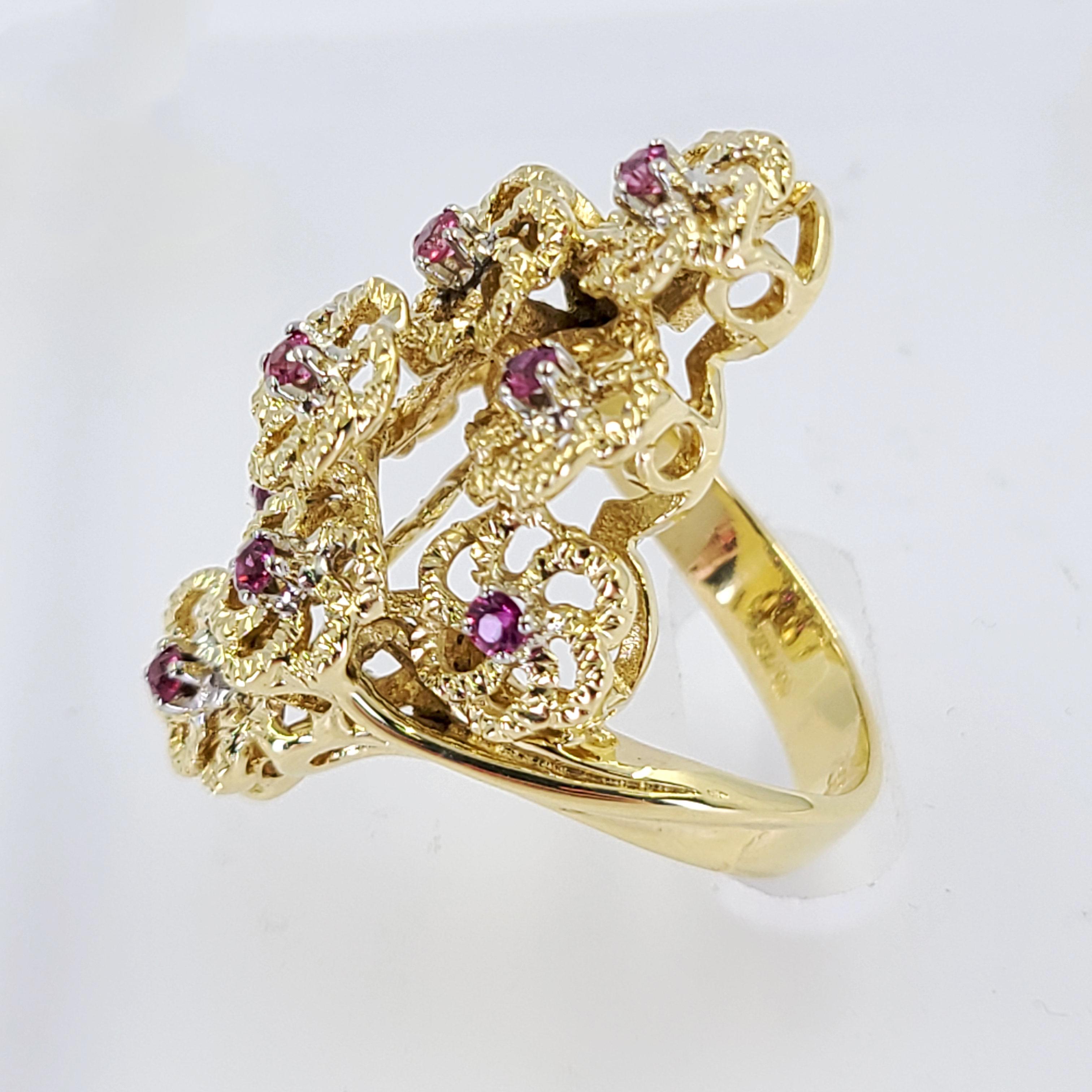 18 Karat Yellow Gold Dinner Ring Featuring 9 Round Rubies Totaling Approximately 0.30 Carats On A Swirled Flower Design. Finger Size 5.5; Purchase Includes One Sizing Service Prior to Shipment. Finished Weight Is 10.0 Grams.