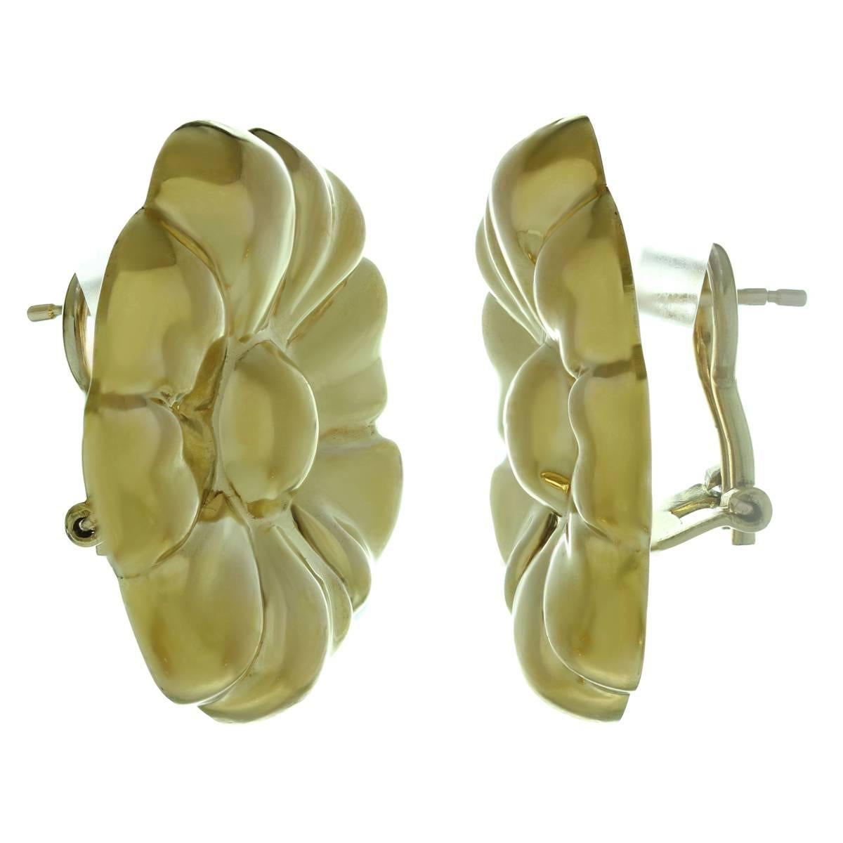 These fine Italian earrings are made in solid 14k yellow gold and feature a round floral design completed with lever backs. Measurements: 1.06