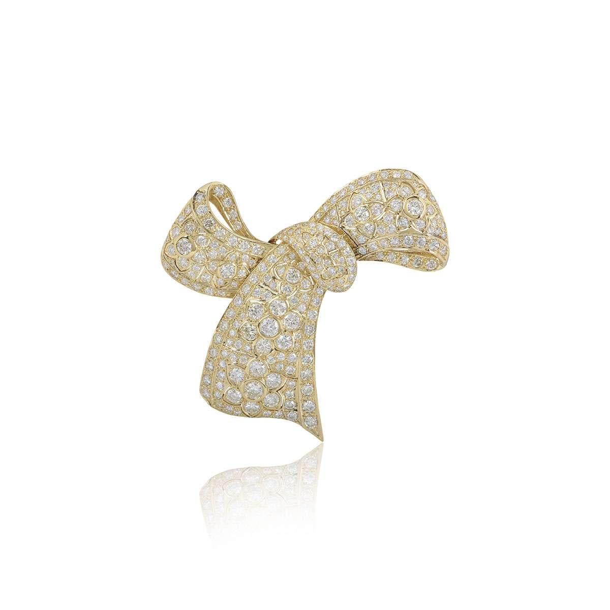 A stunning 18k yellow gold diamond Bow brooch. The brooch is set with round brilliant cut diamonds varying in size, totalling approximately 10.29ct. The brooch measures 6.5cm in width and 7cm in length and has a pin closure to the reverse. The