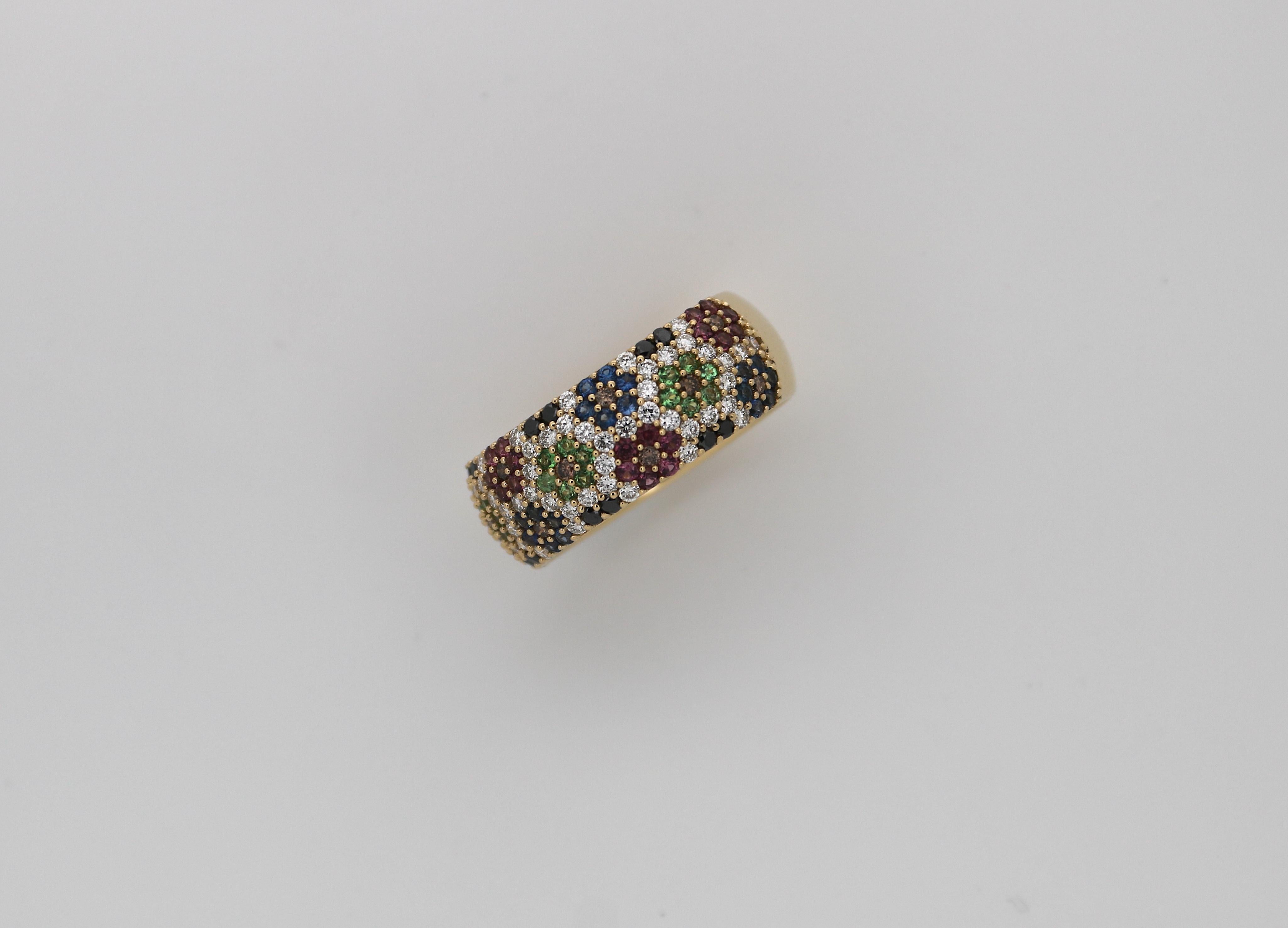 A handmade 18k yellow and white gold cocktail band ring  pave set with brilliant cut diamonds, sapphires, rubies and peridots. 

The ring is in very good condition and has been verified by one of our master goldsmiths. 

Ring size: US 7 1/2 / EU