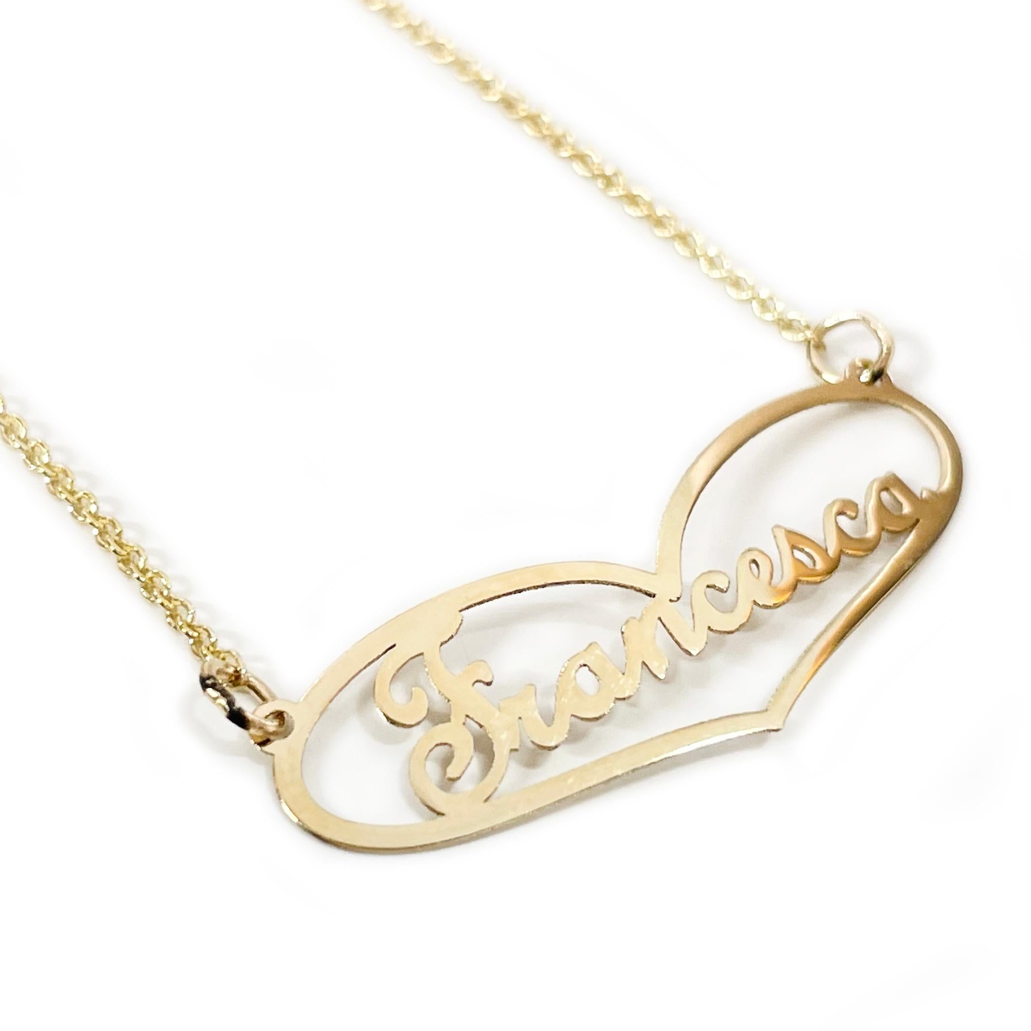 10 Karat Yellow Gold Francesca Name Pendant Necklace. The necklace features an elongated heart shape pendant with the name Francesca inside the heart in a cursive font. The chain is 18