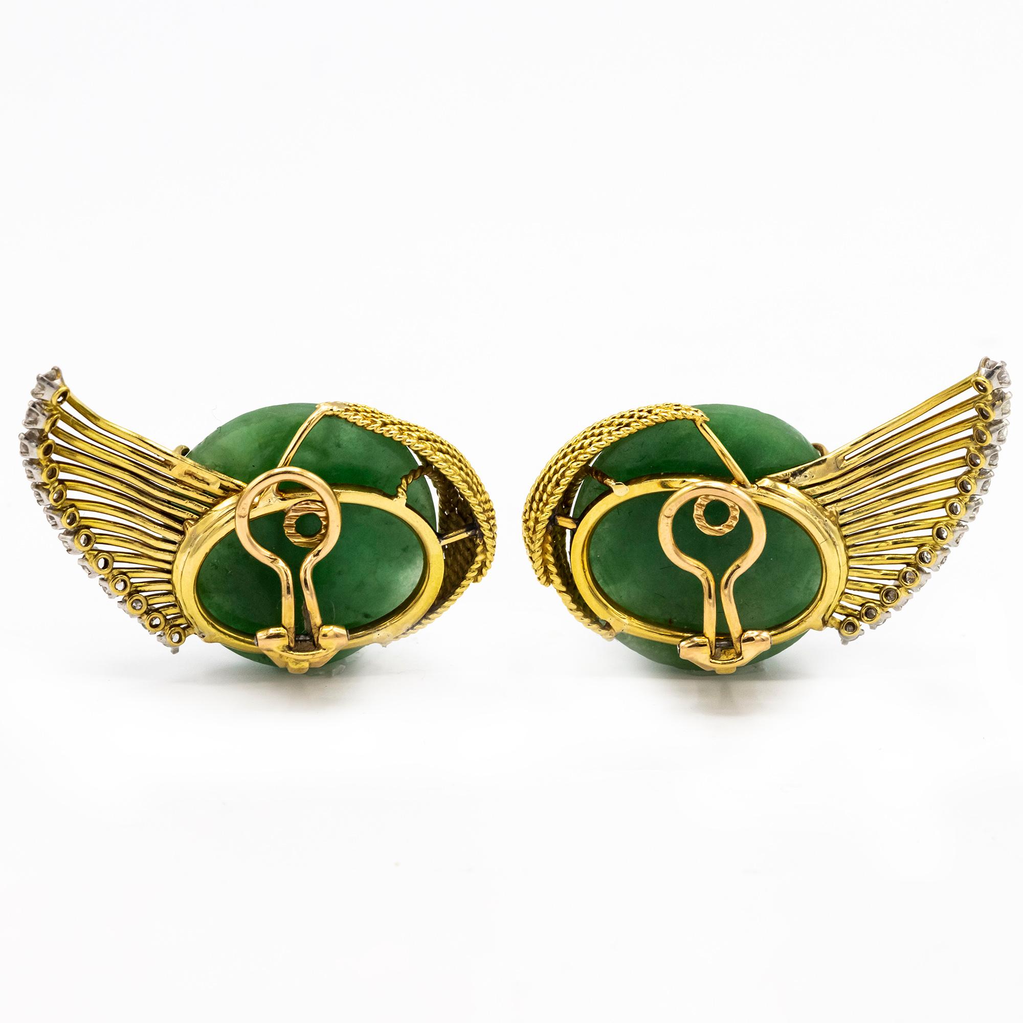 Vintage Handcarved Jade Faces Ear clips with Gold Diamond-Accented Wings.
2 carved jade faces ap. 23.0 & 22.3 mm., 24 round diamonds ap. .85 ct., clip-backs with French import marks, c. 1945-1950, ap. 16 dwts. gross.
Jade: mossy green, translucent,