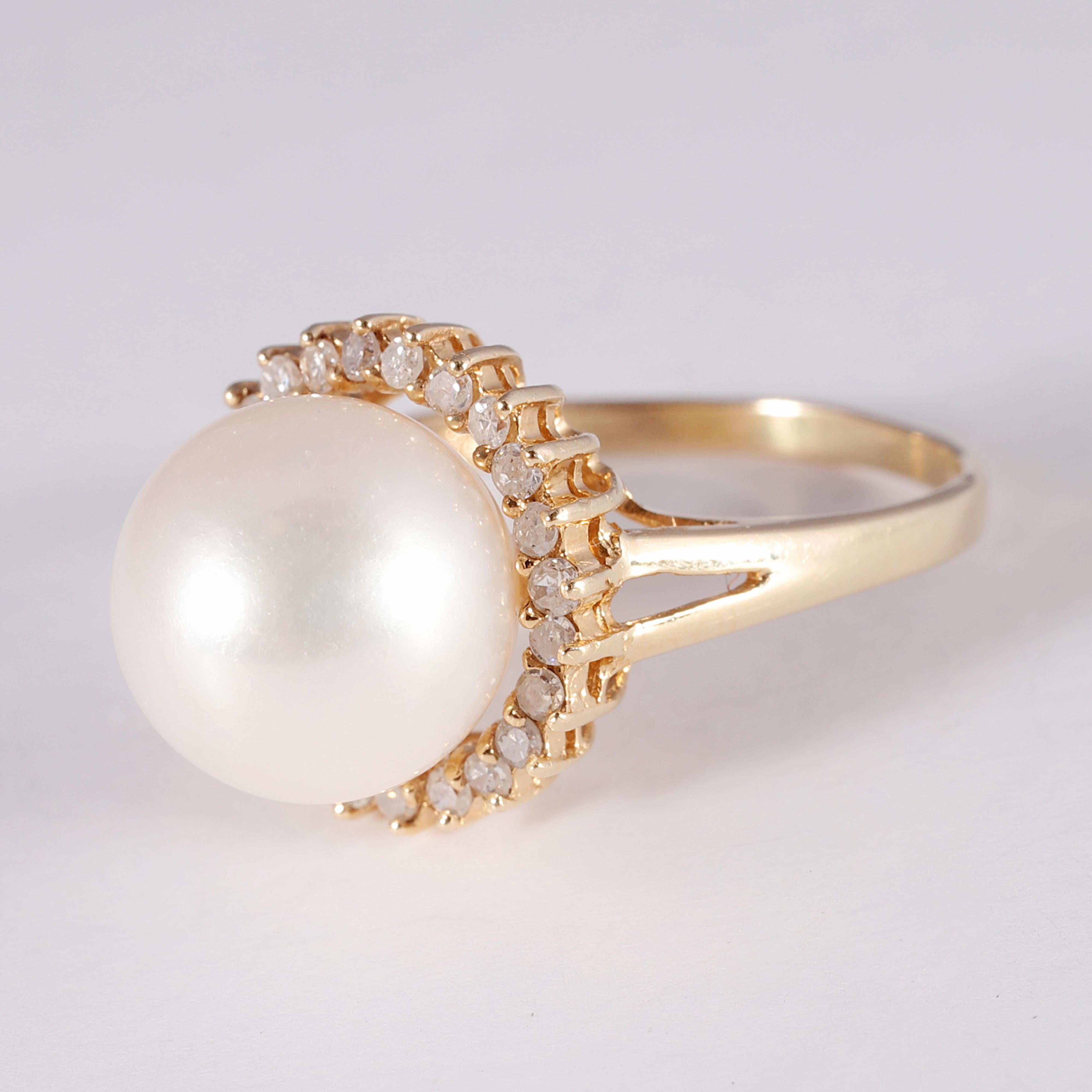 Such a lovely 10.00 mm freshwater cultured pearl is at the center of this 14 karat yellow gold ring!  It is surrounded by 0.28 carats of prong-set, round diamonds and is a size 7 3/4.