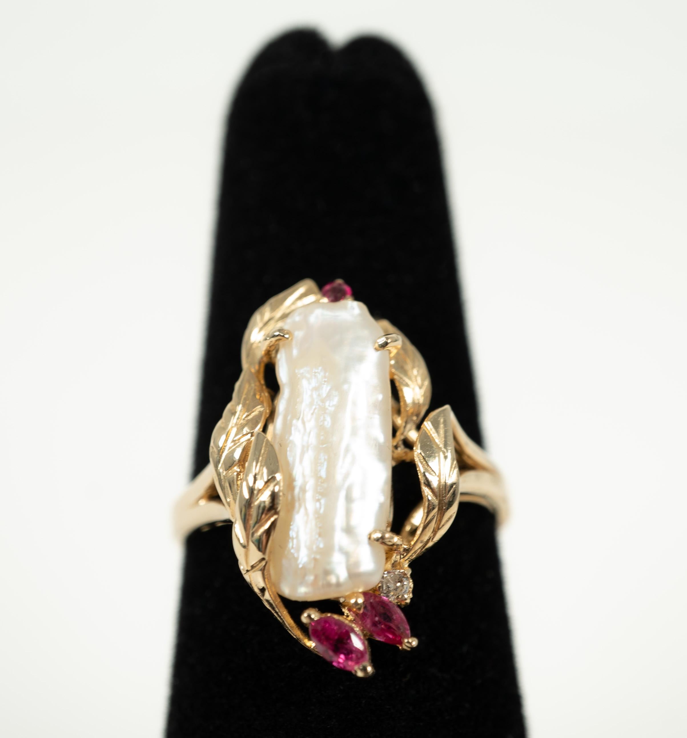 In 14 karat yellow gold, this freshwater pearl is accented with rubies and one diamond. 