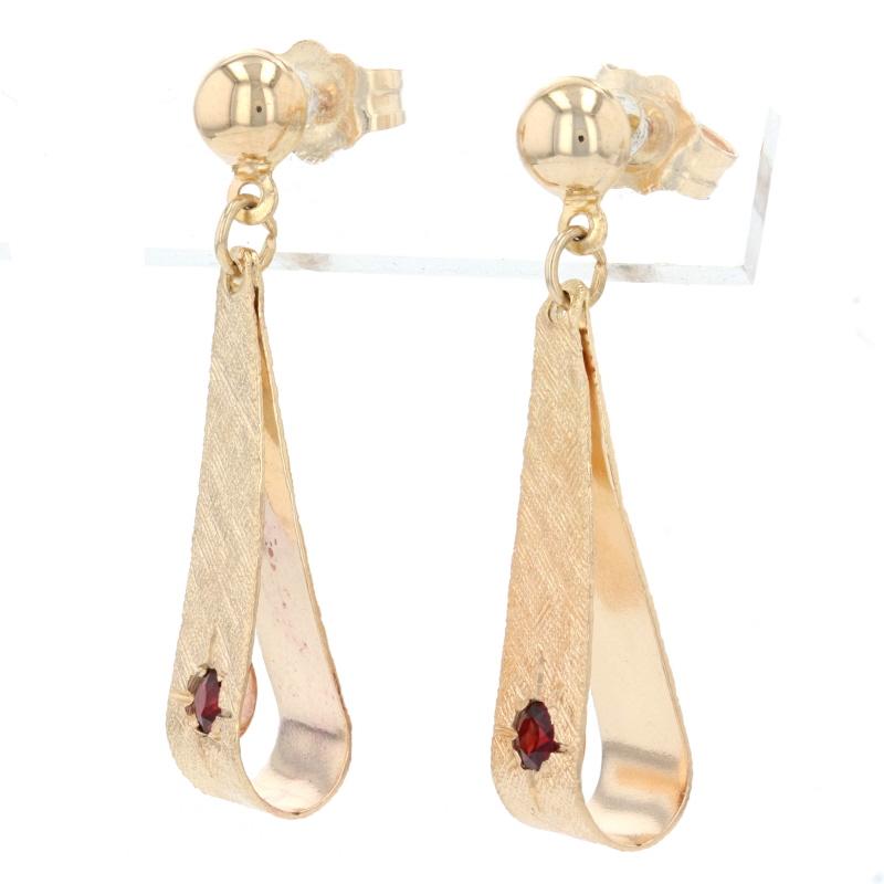 Metal Content: 14k Yellow Gold

Stone Information: 
Genuine Garnets
Total Carats: .20ctw
Cut: Round
Color: Red

Style: Dangle
Fastening Type: Butterfly Closures
Theme: Ribbon
Features: Smooth & Crosshatch Finishes

Measurements: 
Tall: 1 1/8