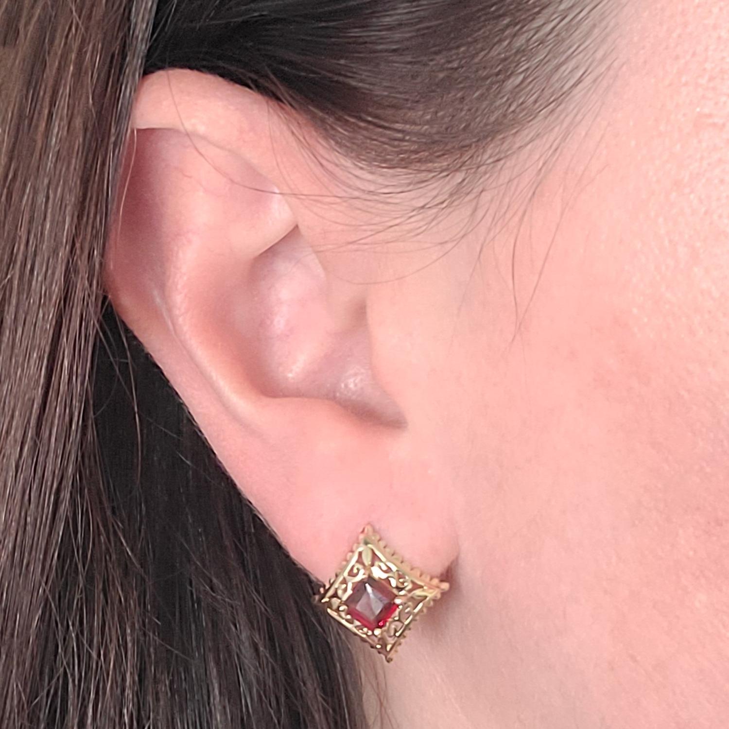 14 Kart Yellow Gold Earrings Featuring 2 Square Cut 5mm Garnets & A Convex Cutout Design. Finished Weight Is 2.4 Grams. Pierced Post With Friction Back.