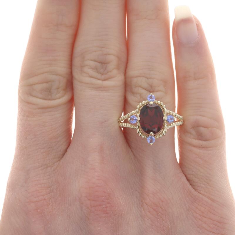 Size: 9 1/4
Sizing Fee: Up 2 sizes for $35 or Down 2 sizes for $30

Metal Content: 14k Yellow Gold

Stone Information

Natural Garnet
Carat(s): 2.10ct
Cut: Oval
Color: Red

Natural Tanzanites
Treatment: Routinely Enhanced
Carat(s): .28ctw
Cut: