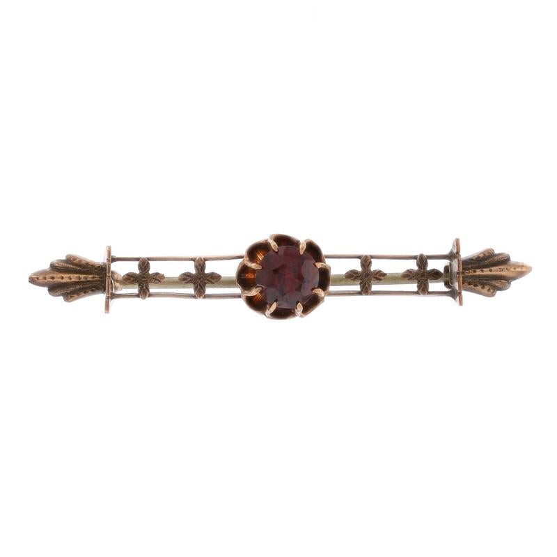 Era: Victorian
Date: 1880s - 1890s

Metal Content: 10k Yellow Gold

Stone Information

Natural Garnet
Cut: Round
Color: Red

Style: Solitaire Bar Brooch
Fastening Type: Hinged Pin and Covered C-Clasp
Theme: Floral Cross
Features: Buttercup Stone