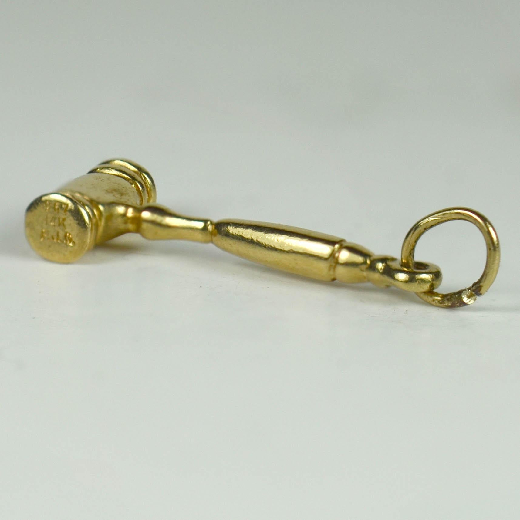A 14 karat yellow gold charm pendant designed as an auctioneer's or lawyer's gavel (hammer). 
Marked 14K F.J.G. and numbered 967.

Dimensions: 3 x 0.9 x 0.4 cm
Weight: 2.31 grams.