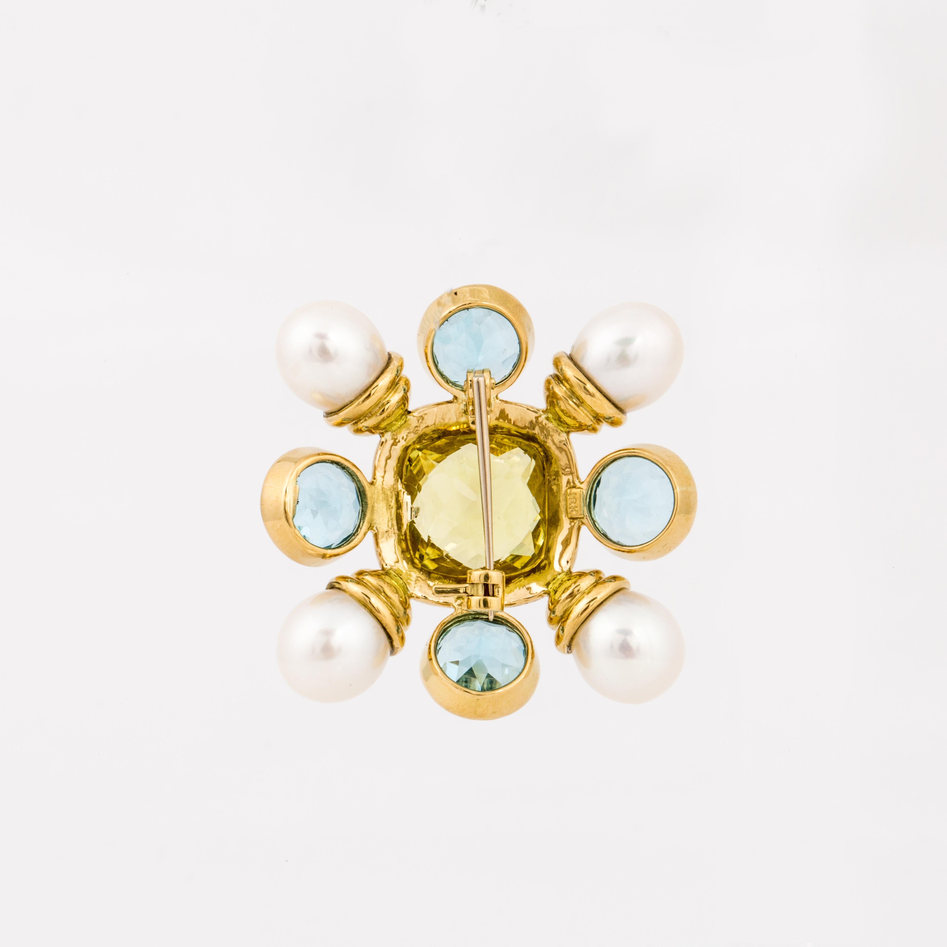 18K yellow gold pin set with pearls, blue topaz and Peridot.  There are four (4) cultured pearls measuring 8.9mm - 9.4mm.  In addition, there are four (4) round faceted Blue Topaz and one (1) cushion cut Peridot.  Measures 1-5/8