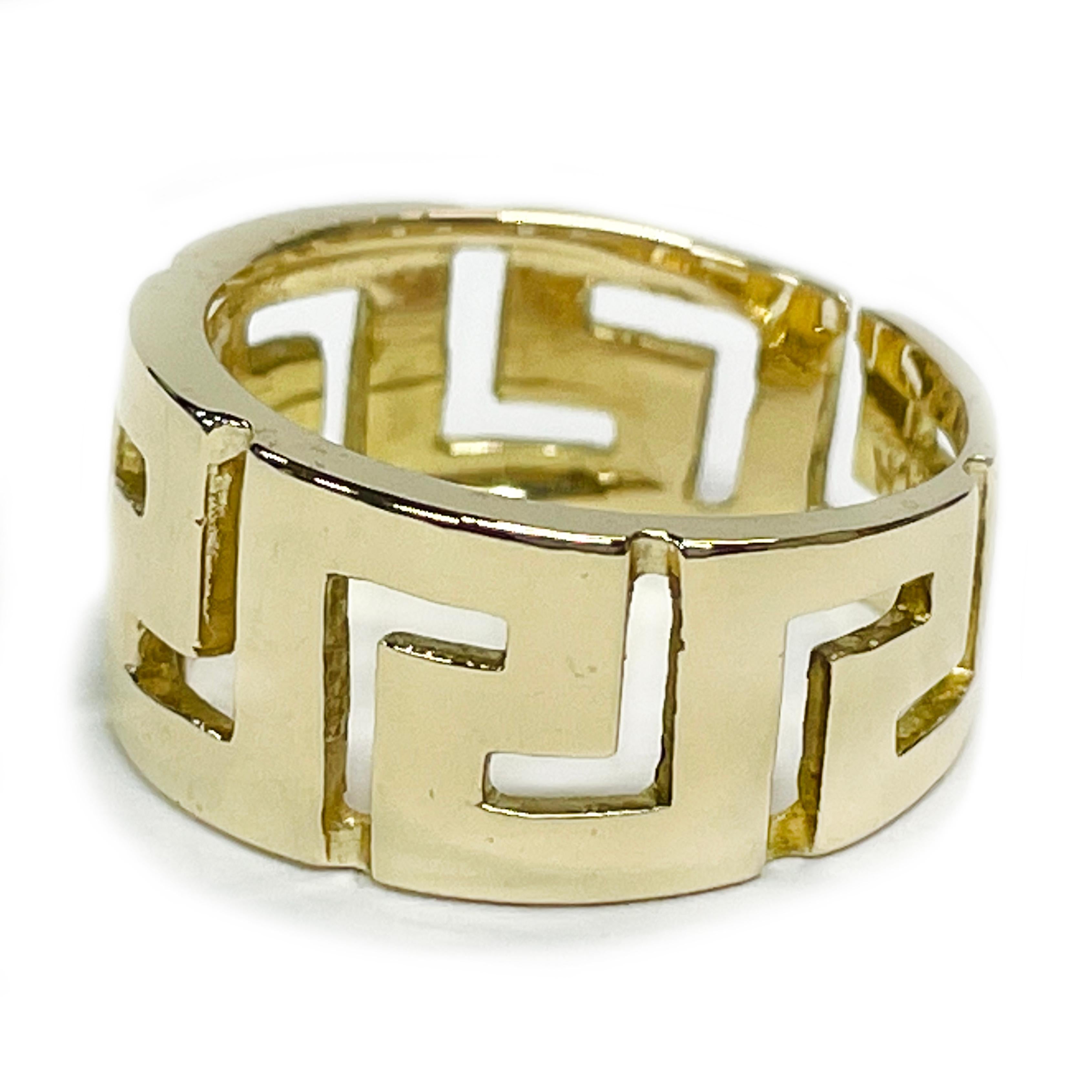 14 Karat Yellow Gold Greek Key Eternity Ring. This ring features a repeat pattern of Greek Keys cut away on the band. The tapered ring ranges in width from 10 to 7.5mm. The ring has an overall smooth shiny finish. Stamped on the inside of the band