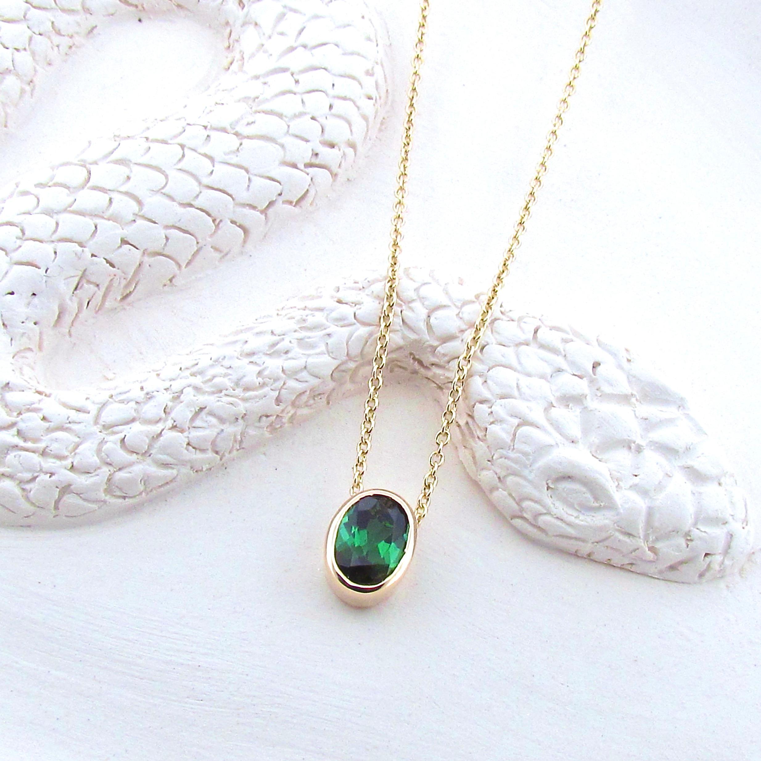 This 9ct solid gold small oval pendant is set with a beautifully faceted bright natural 1ct Green Tourmaline, and comes on a 40cm/16inch 9ct yellow gold cable chain, it is superior in quality and has a nice weight to it. The deep Green hue of