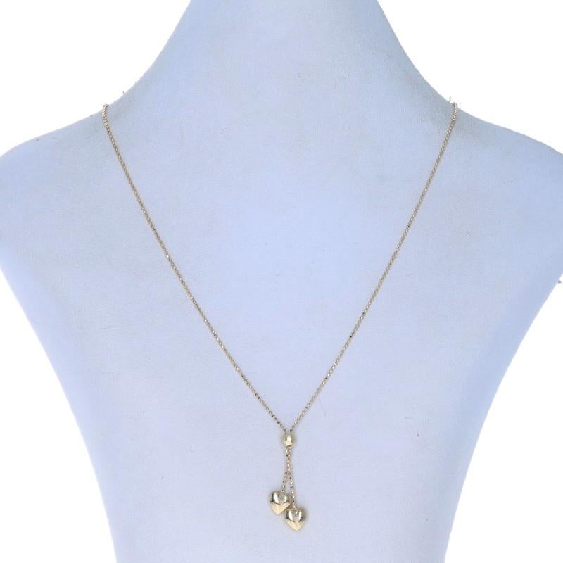 Metal Content: 14k Yellow Gold

Style: Lariat
Chain Style: Diamond Cut Bead
Necklace Style: Chain
Fastening Type: Spring Ring Clasp
Theme: Heart Duo, Love

Measurements

Item 1: Lariat
Tall (from top of ball to base of longest heart): 1 5/16