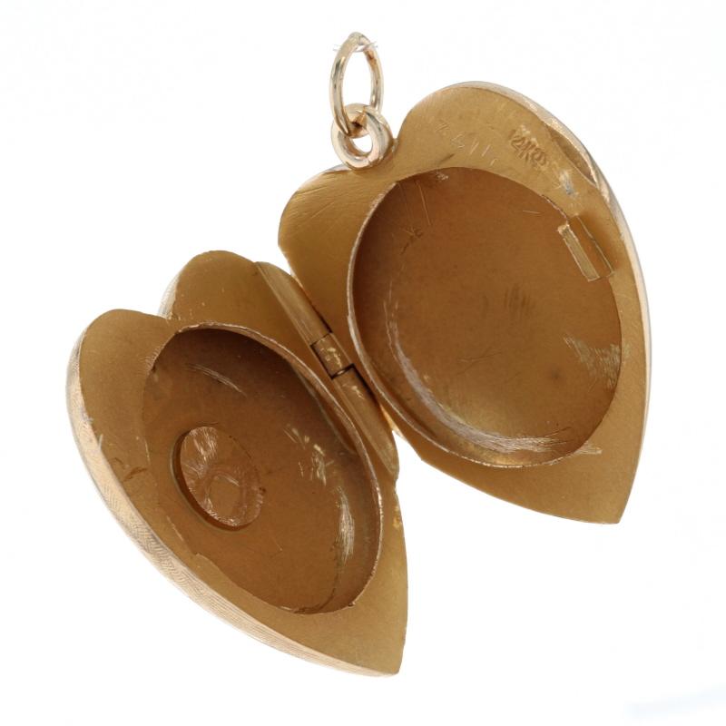 Metal Content: 14k Yellow Gold

Style: Locket 
Theme: Heart, Love
Features: Reversible & Engravable Two Photo Frame Design with Smooth & Crosshatch Finishes

Measurements
Tall (from stationary bail): 29/32