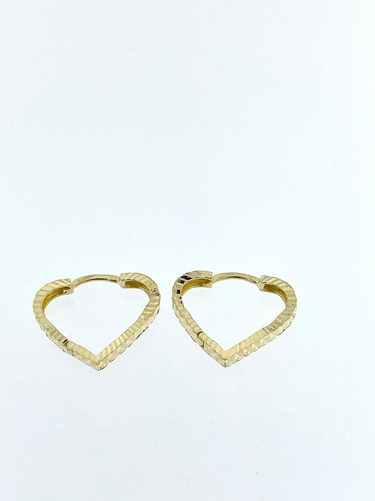 The Yellow Gold Heart Shaped Hoop Earrings, crafted in 18-karat gold, offer a blend of charm and sophistication. These earrings feature a unique heart-shaped hoop design, adding a touch of romance to any ensemble.

The relief work on the earrings