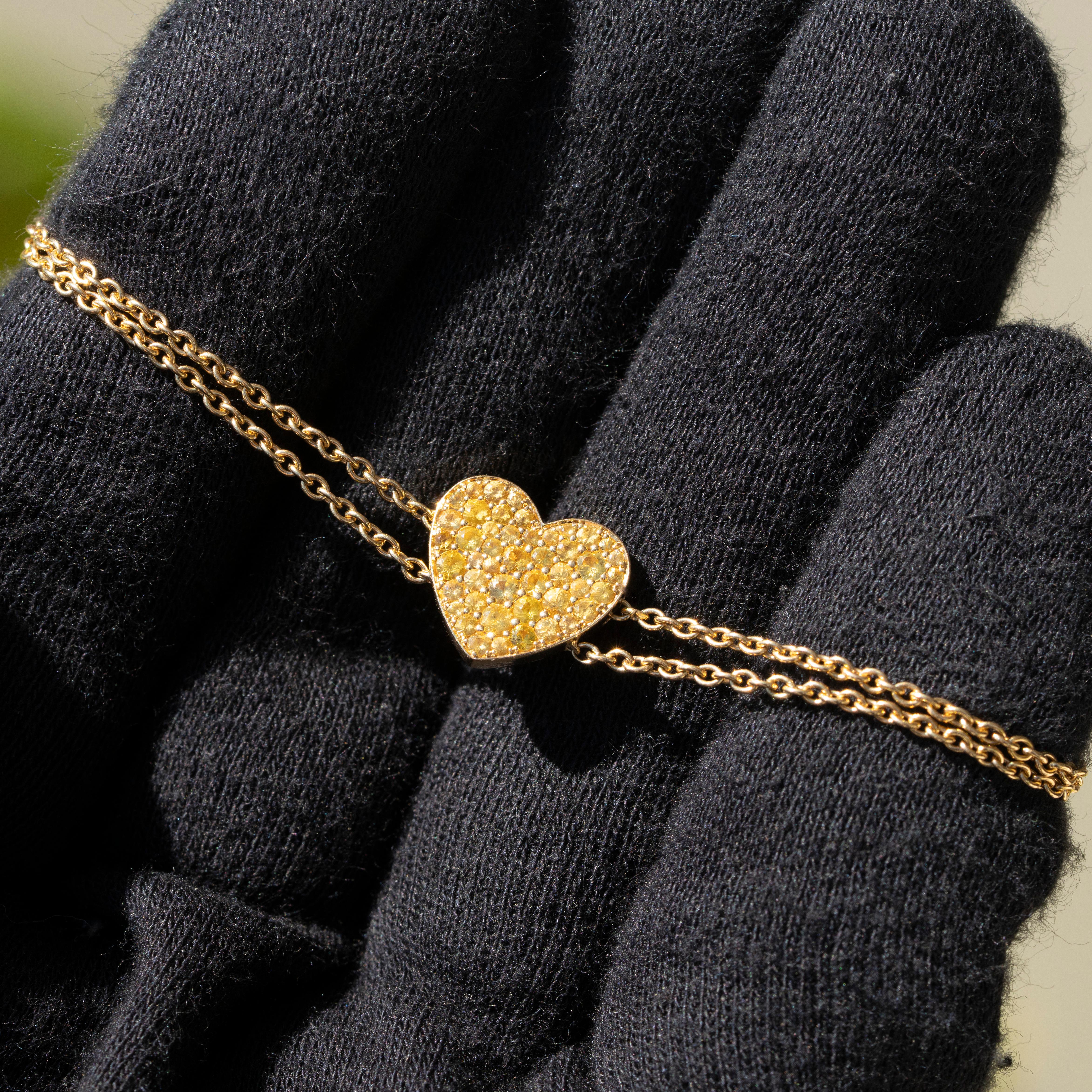 This charming 18k yellow gold bracelet is a delightful expression of elegance and warmth, featuring a heart-shaped design adorned with natural round brilliant citrines. The vibrant citrines, known for their rich golden hue, are meticulously set to