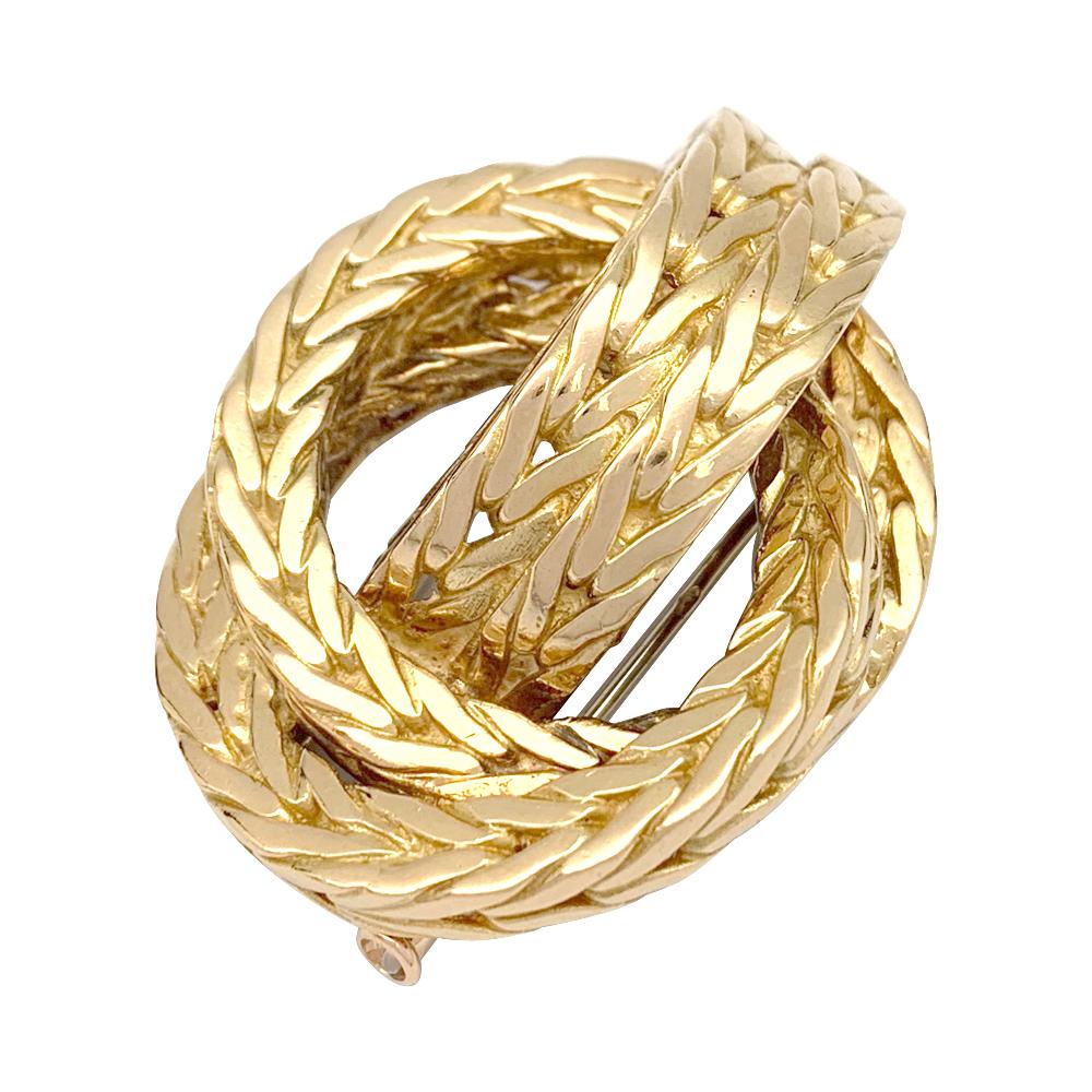 A 18kt braided yellow gold Hermès brooch designed as a knot. 
Signed and numbered.
Circa 1970