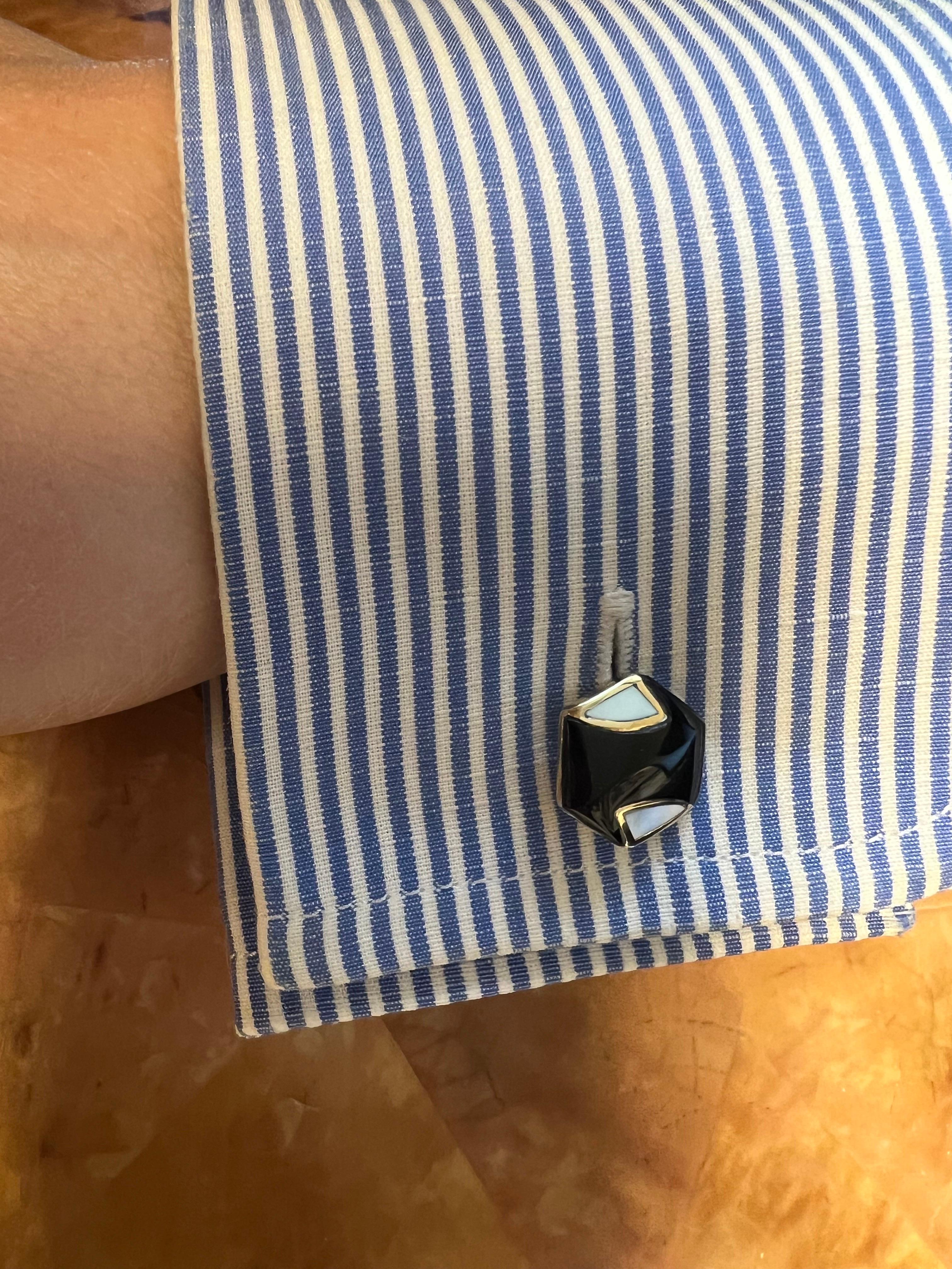 These double-sided cufflinks are a stunning accessory for the discerning gentleman. Crafted from 18k yellow gold, they feature a unique hexagon shape that adds a touch of modern sophistication to any outfit. The black onyx and mother-of-pearl stones