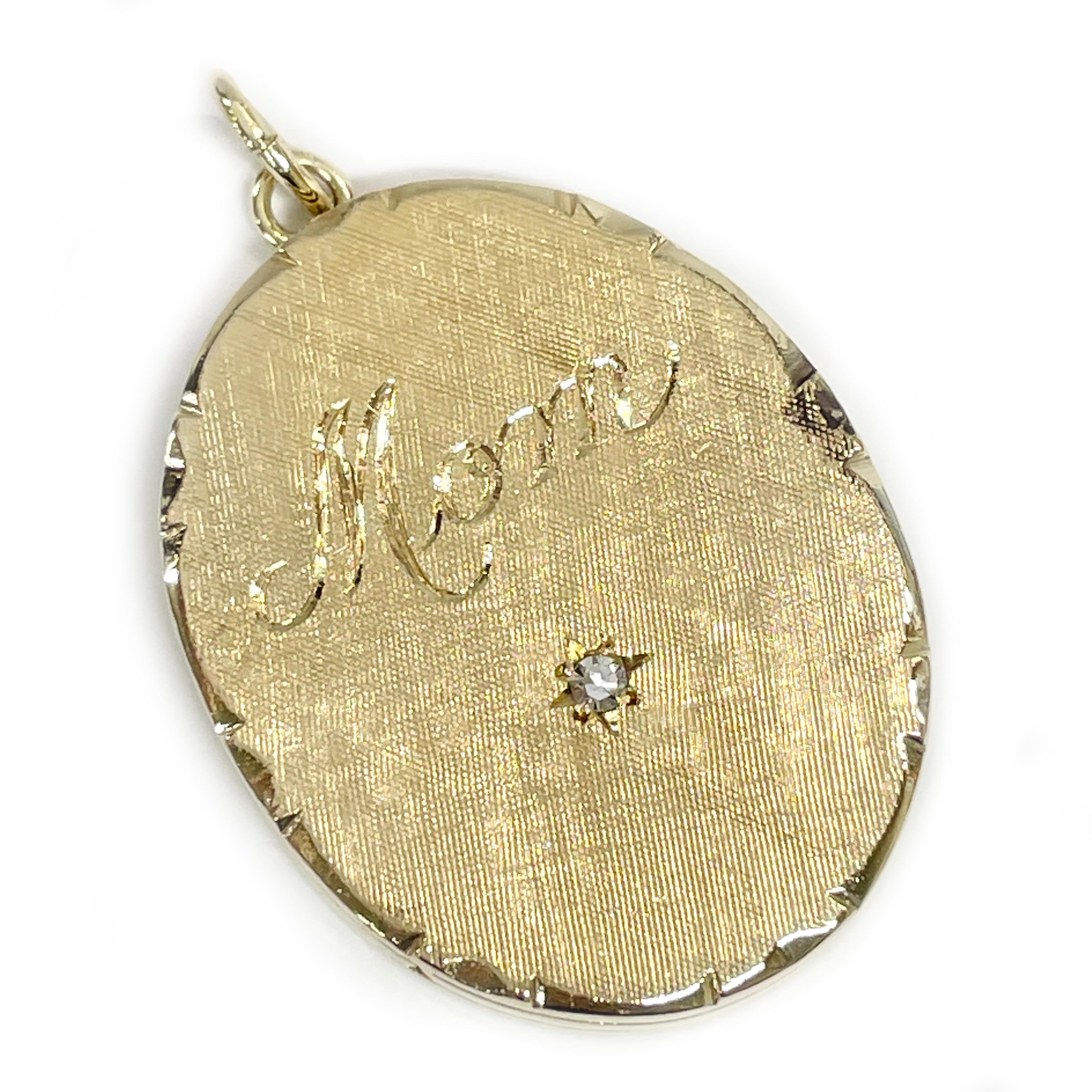 14 Karat Yellow Gold Hinged Diamond Locket Pendant. The front of the oval pendant have a Florentine finish with the word Mom engraved in a cursive font with a starburst cut and a round diamond set in the starburst. The pendant has an overall smooth