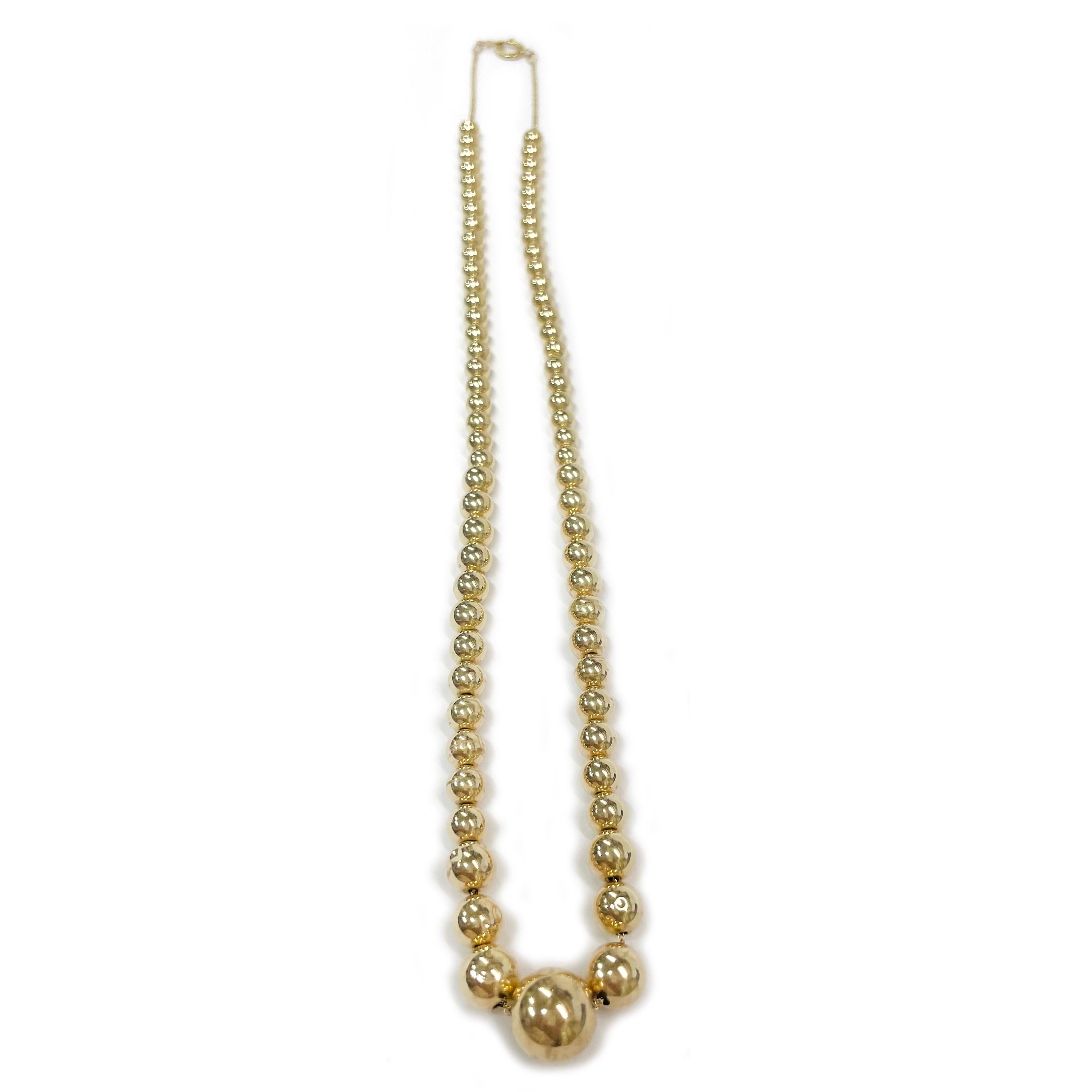 14 Karat Gelbgold hohle Perlenkette. Die Halskette besteht aus einem einzigen Strang mit vierundsiebzig hohlen, runden Perlen aus Gelbgold. Die Größe der Perlen reicht von 4,85 bis 11 mm. Die Perlen hängen an einer Gliederkette aus 14 Karat Gold.