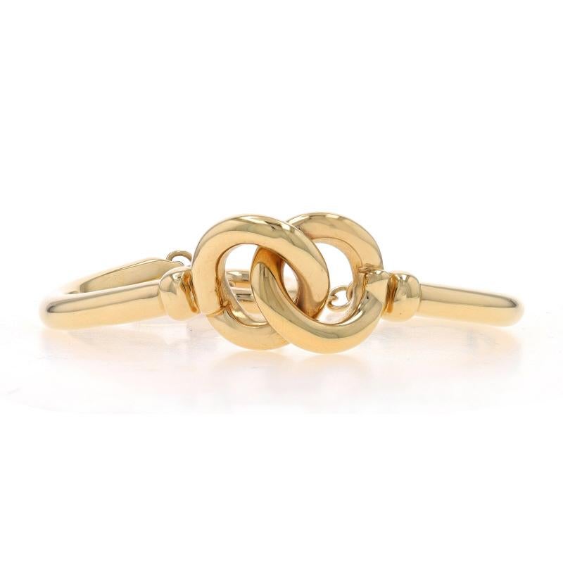 Metal Content: 14k Yellow Gold (with resin filled core)

Style: Bangle-Inspired Curved Link
Fastening Type: Toggle Clasp
Theme: Knot, Intertwined Circles

Measurements
Inner Circumference: 6 3/4