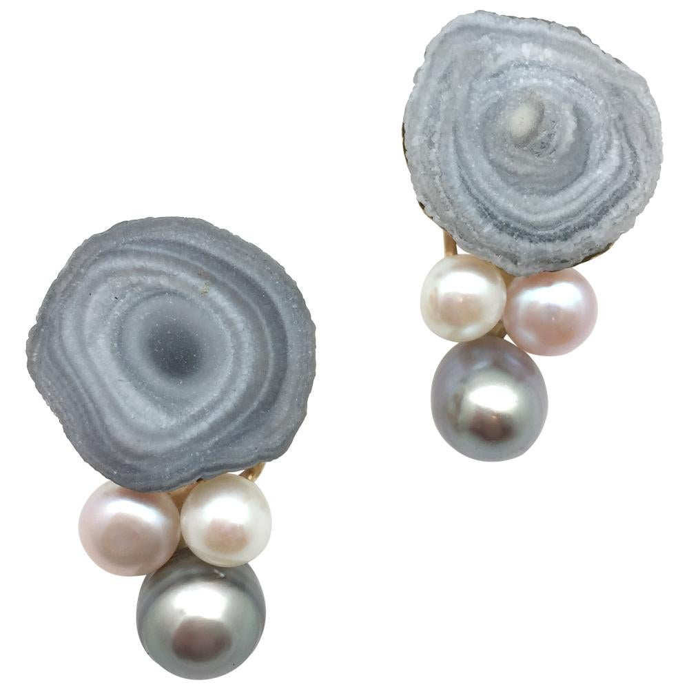 A 750/000 yellow gold Jean Vendôme pair of earrings set with a grey-blue calcedony holding three pearls of blue, pink and white colour. 