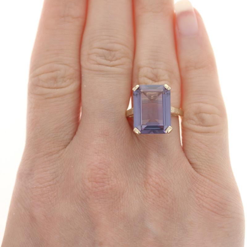 Size: 6 1/4
Sizing Fee: Down 1 size for $30 or up 2 sizes for $35

Era: Vintage

Metal Content: 10k Yellow Gold

Stone Information
Synthetic Color Change Sapphire
Carat(s): 12.12ct
Cut: Emerald 
Color: Purple to Purplish Green

Total Carats:
