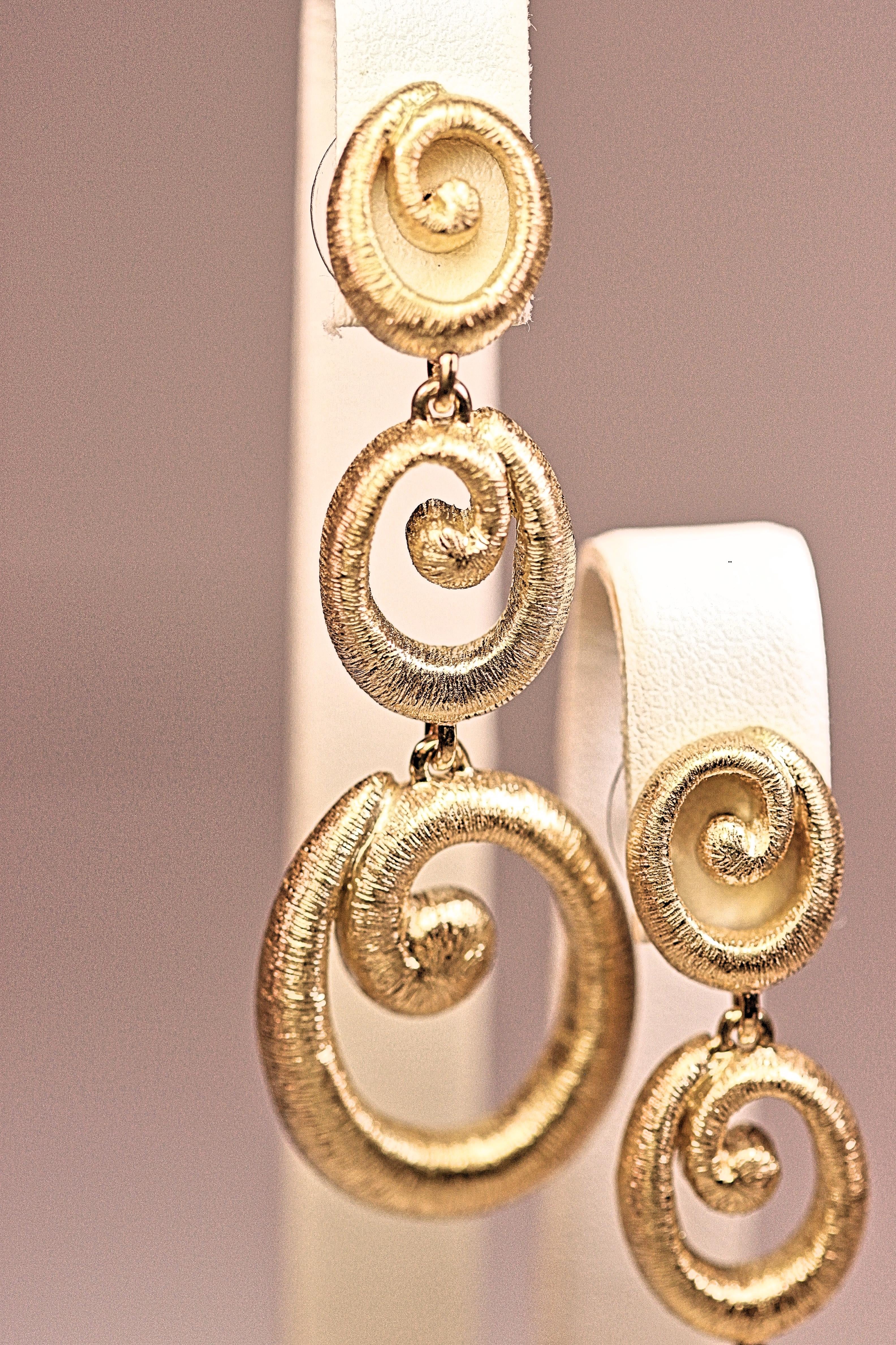 A fabulous pair of textured gold earrings  The earrings are 18K yellow gold and they are a dangle design that measure 2 1/4inches long, 3/8 inches wide at the top and 3/4 inch wide at the bottom. Very substantial and comfortable to wear. 