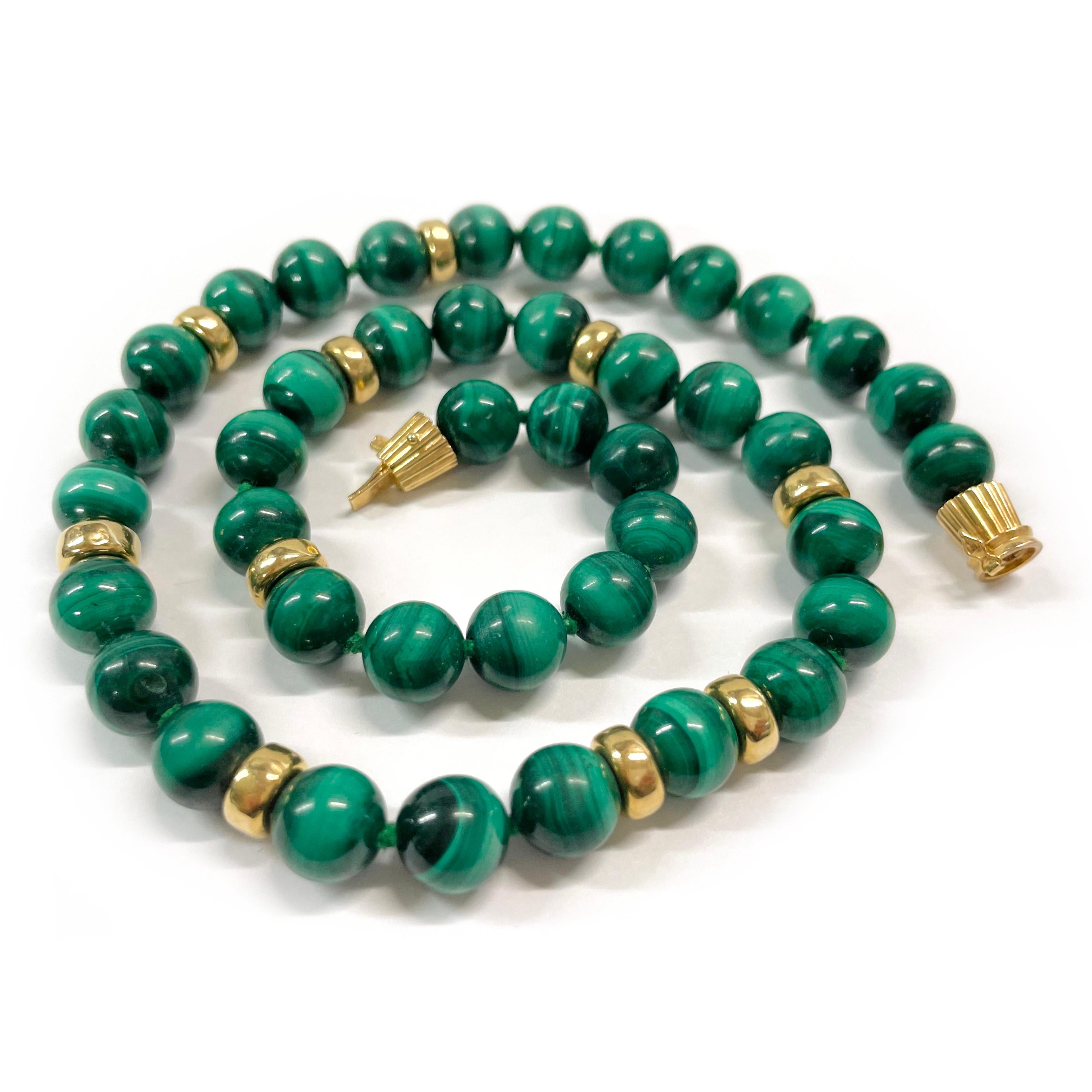 14 Karat Yellow Gold Malachite Beaded Necklace. The necklace features forty-one round malachite beads and ten rondelle gold beads in a single strand. The malachite beads measure 10mm in diameter and the rondelle gold beads measure 8.5mm. The