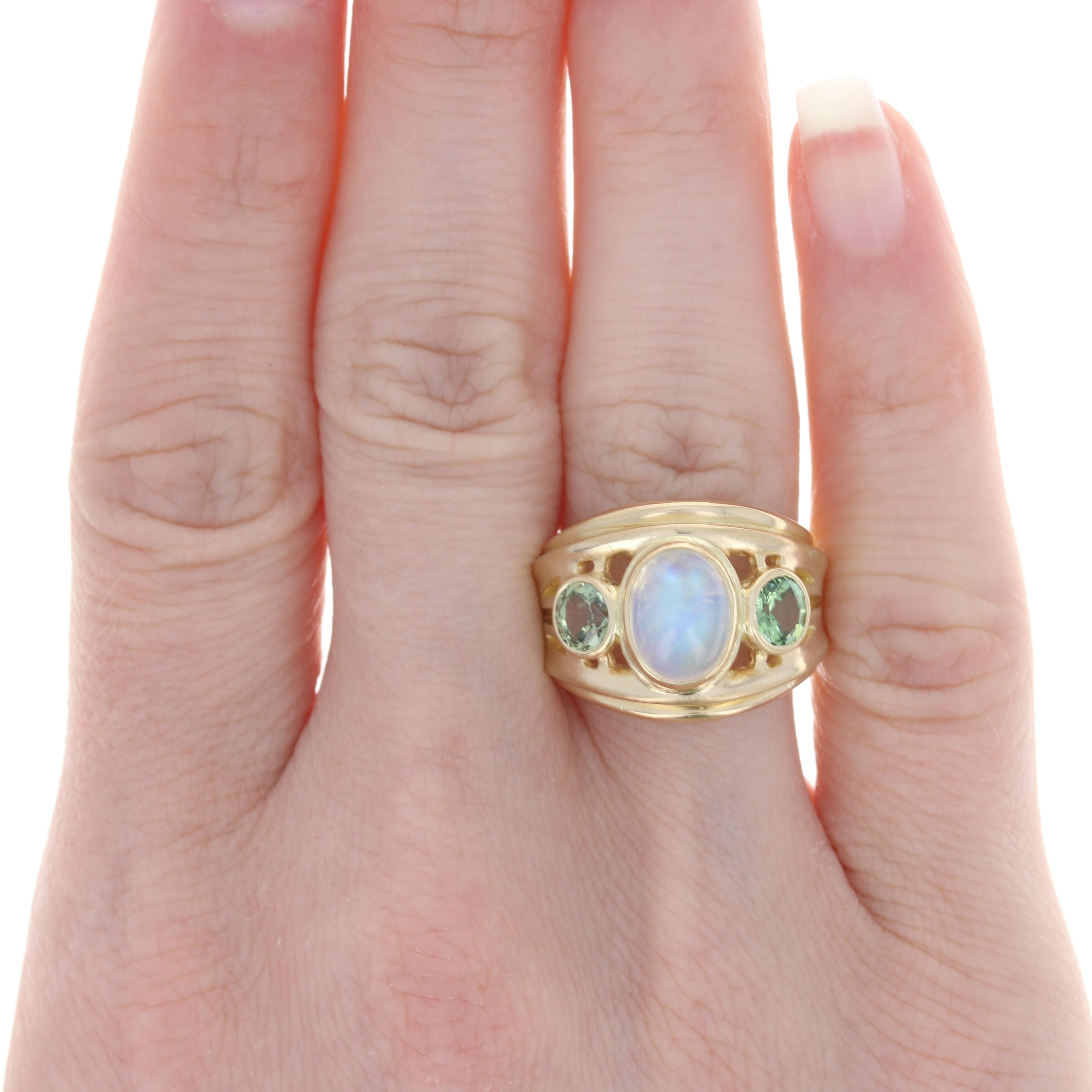 Size: 8
 
 Metal Content: 18k Yellow Gold 
 
 Stone Information: 
 Genuine Moonstone
 Carat: 2.40ct
 Cut: Cabochon
 
 Genuine Sapphires
 Treatment: Heating
 Carats: 1.20ctw
 Cut: Round
 Color: Green
 
 Total Carats: 3.60ctw
 
 Style: Solitaire with