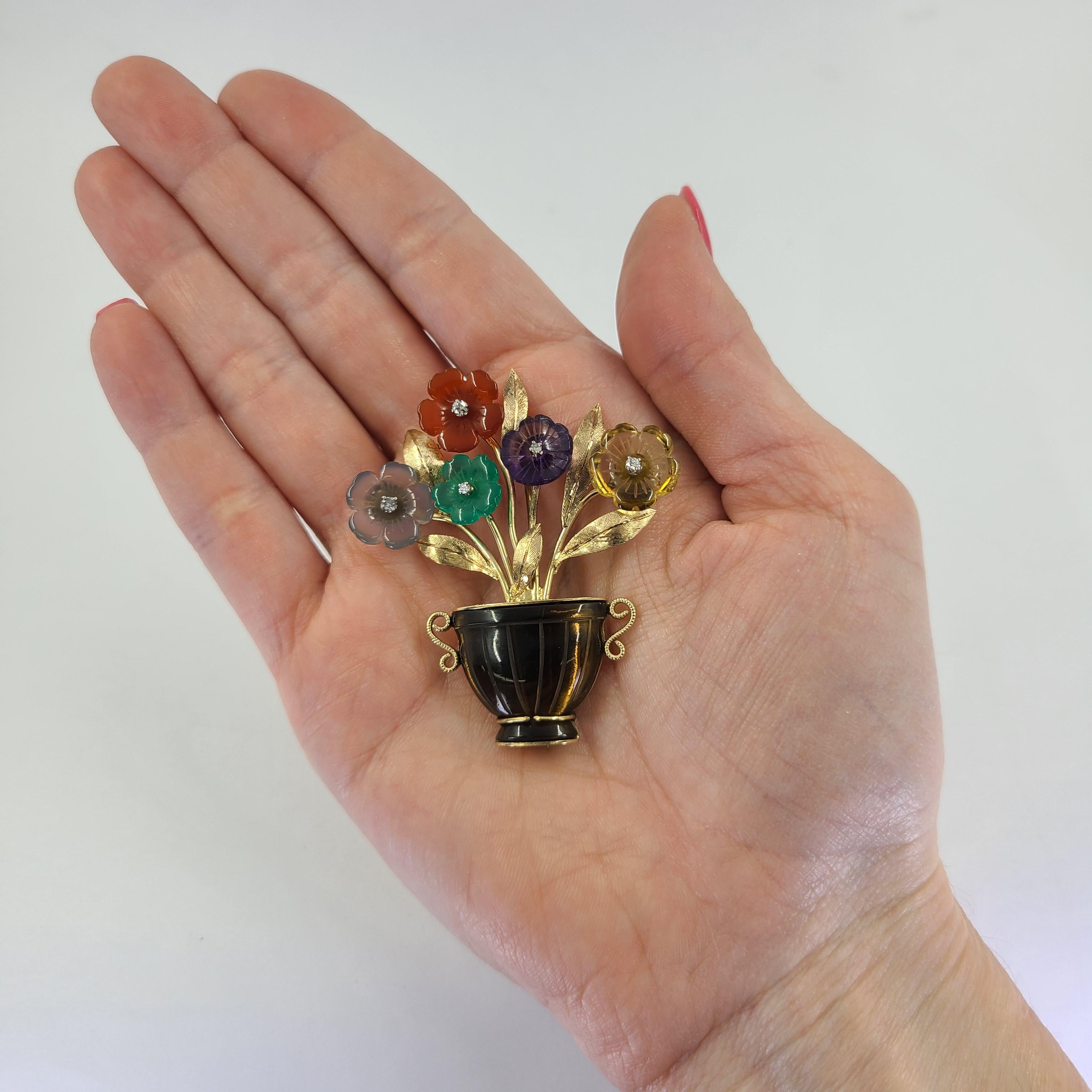 14 Karat Yellow Gold Flower Pot Brooch Featuring Spinning Carved Citrine, Amethyst, Chalcedony, Smokey Quartz, & Carnelian Accented By 5 Round Diamonds. 2.13 Inch Length. Finished Weight Is 13.9 Grams.