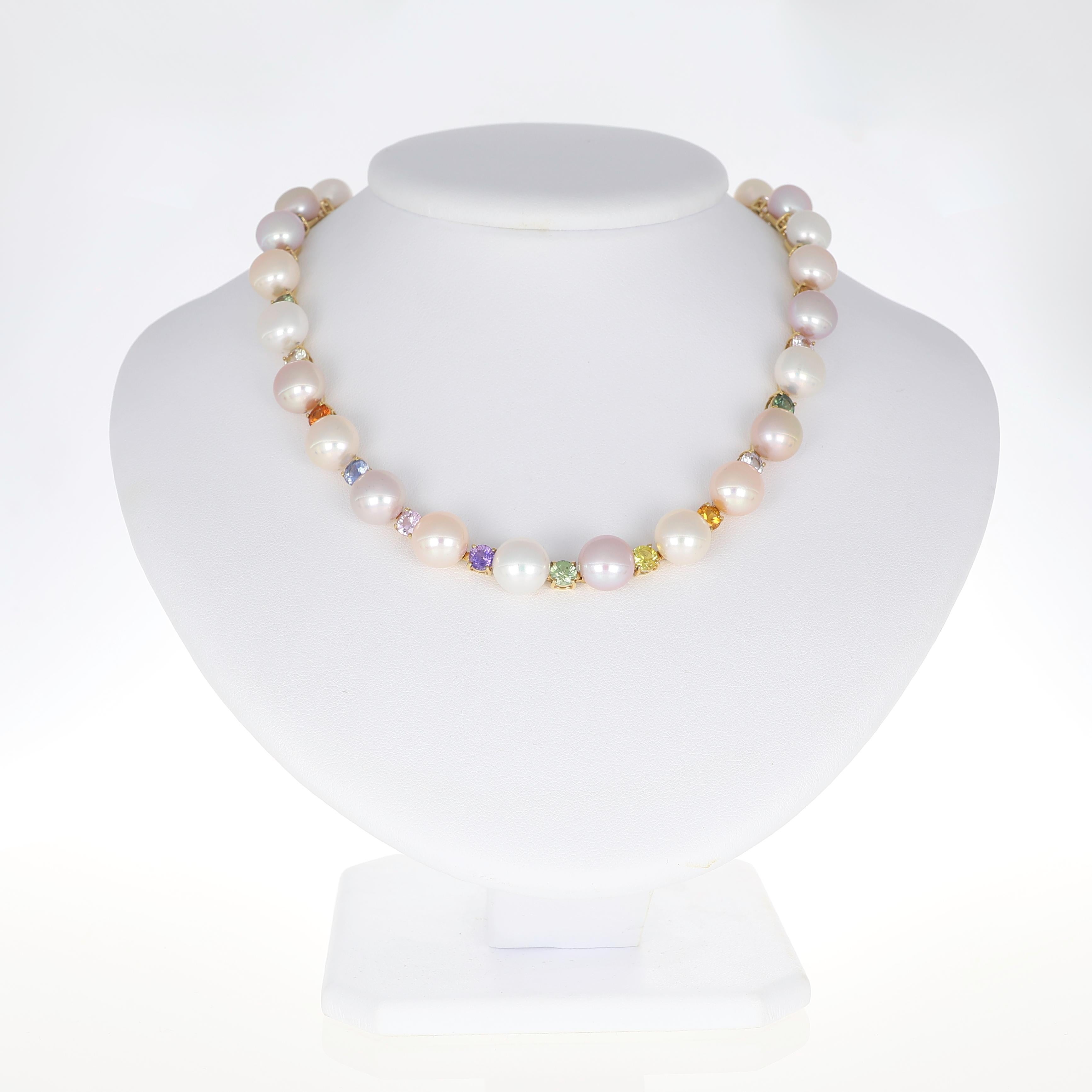 Una collana sofisticata che unisce l'eleganza classica alle pietre preziose. Realizzato in oro giallo, questo pezzo presenta un'armoniosa sequenza di perle luminose, ognuna con una morbida tonalità naturale, intervallate da zaffiri multicolori
