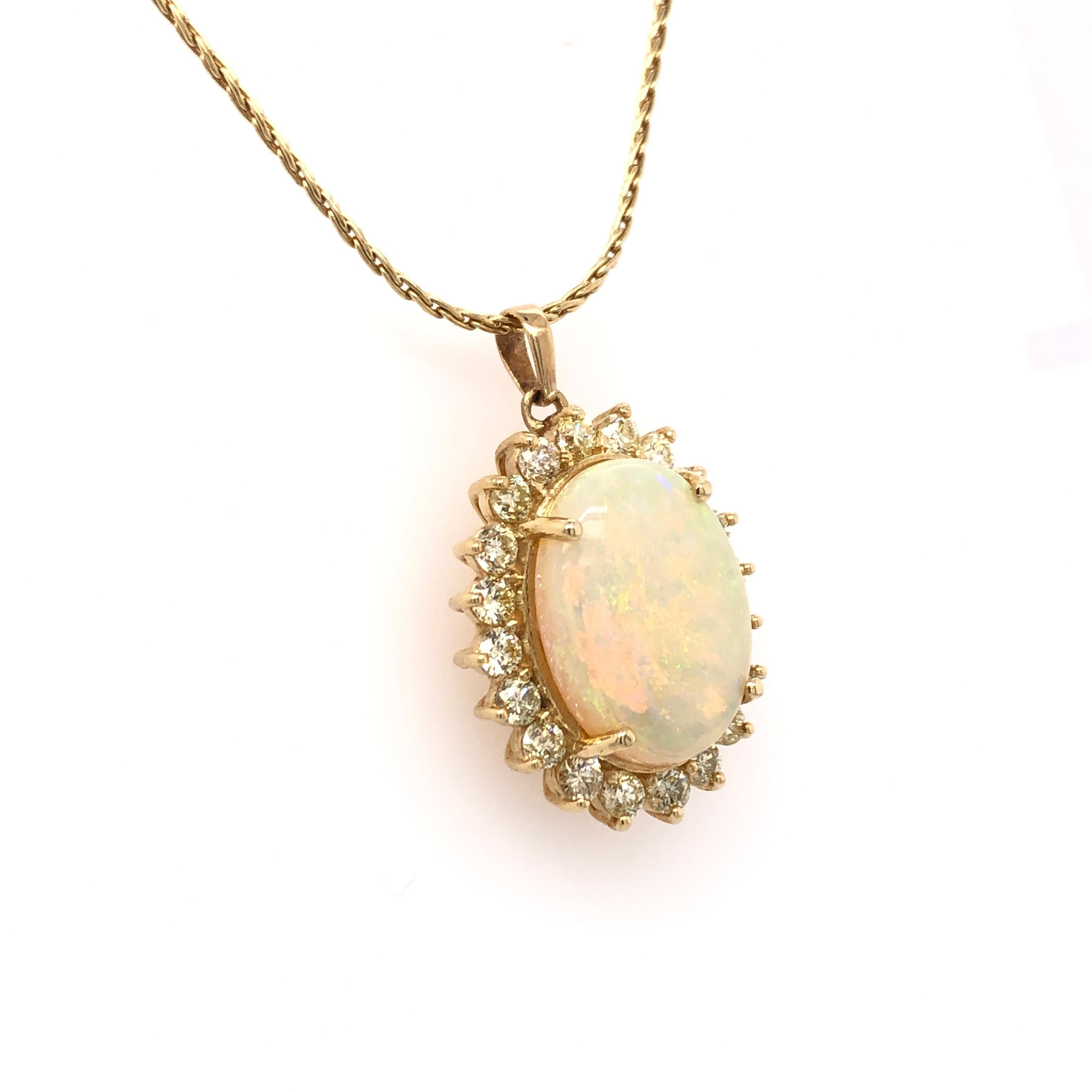A large, beautiful white opal is surrounded by twenty 3 mm round diamonds all set in to an elegant 18K yellow gold setting. The pendant rests on an 18