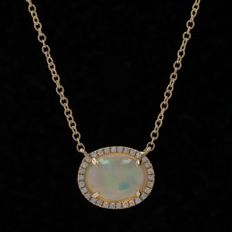 Metal Content: 14k Yellow Gold  

Stone Information: 
Natural Ethiopian Opal
Carat: 1.02ct
Cut: Oval Cabochon
Size: 8.8mm x 6.9mm

Natural Diamonds
Carats: .07ctw
Cut: Single
Color: G   
Clarity: VS1

Total Carats: 1.09ctw

Style: Attached Halo