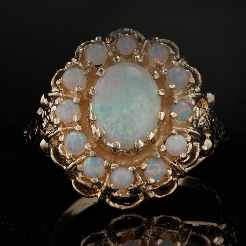 Size: 7
Sizing Fee: Down 2 sizes for $20 or Up 2 sizes for $25

Metal Content: 14k Yellow Gold

Stone Information: 
Genuine Opals
Total Carats: 1.60ctw
Cuts: Oval Cabochon & Round Cabochon
Solitaire's Size: 8.8mm x 6.6mm

Style: Solitaire with