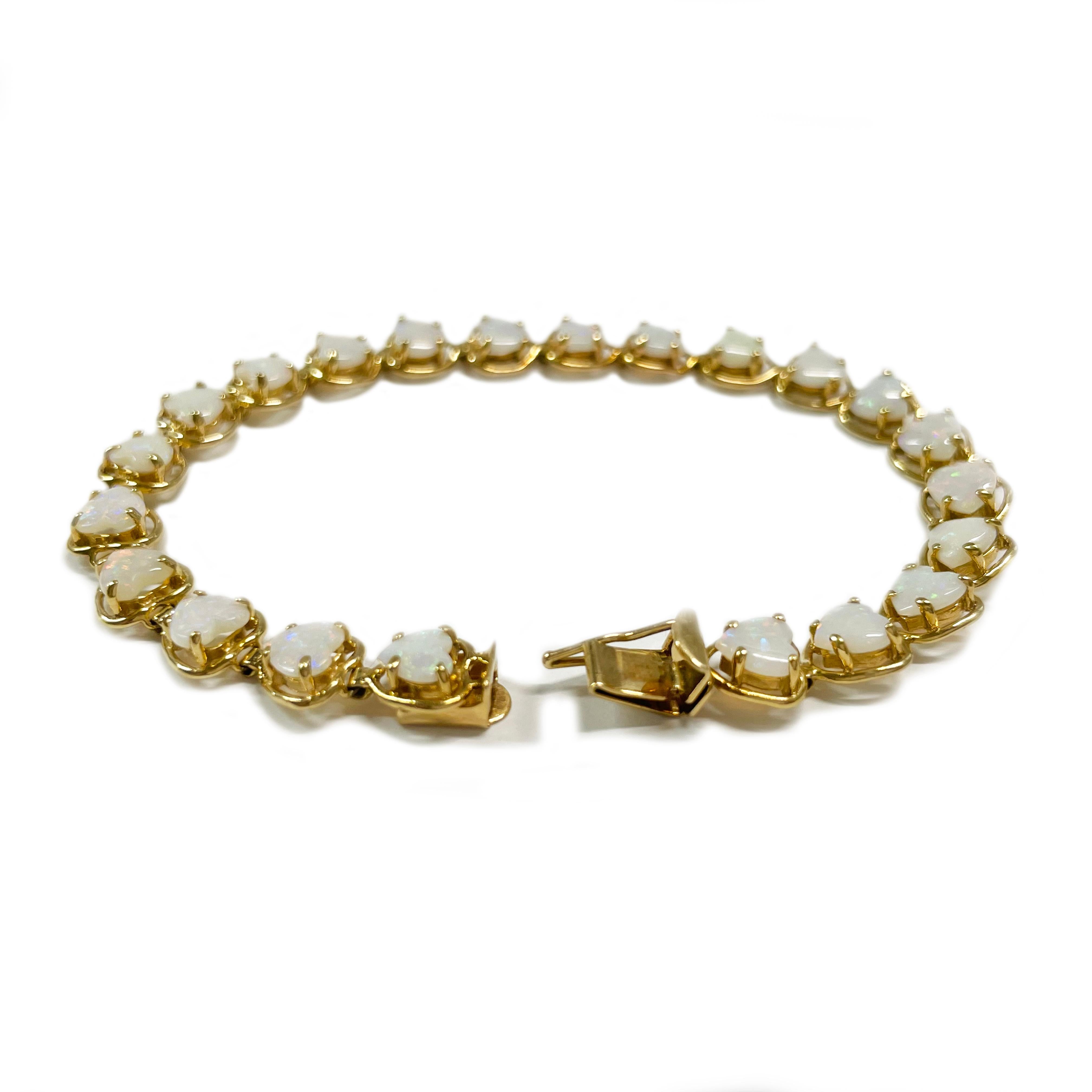 14 Karat Yellow Gold Opal Heart Bracelet. This lovely 1980s link bracelet contains twenty-two heart-shaped Opals set in an open bezel. The opal hearts measure 5 x 4.8mm and the bracelet is 6.5