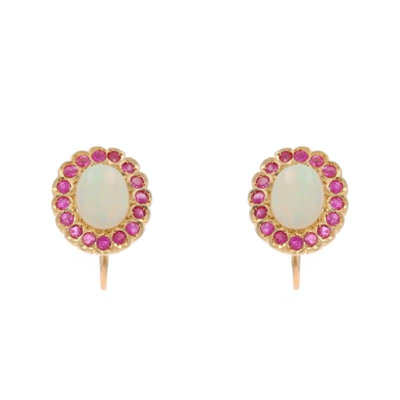 Metal Content: 14k Yellow Gold

Stone Information

Natural Opals
Carat(s): 2.12ctw
Cut: Oval Cabochon
Origin: Australia

Natural Rubies
Treatment: Heating
Carat(s): .96ctw
Cut: Round
Color: Pinkish Red

Total Carats: 3.08ctw

Style: Halo