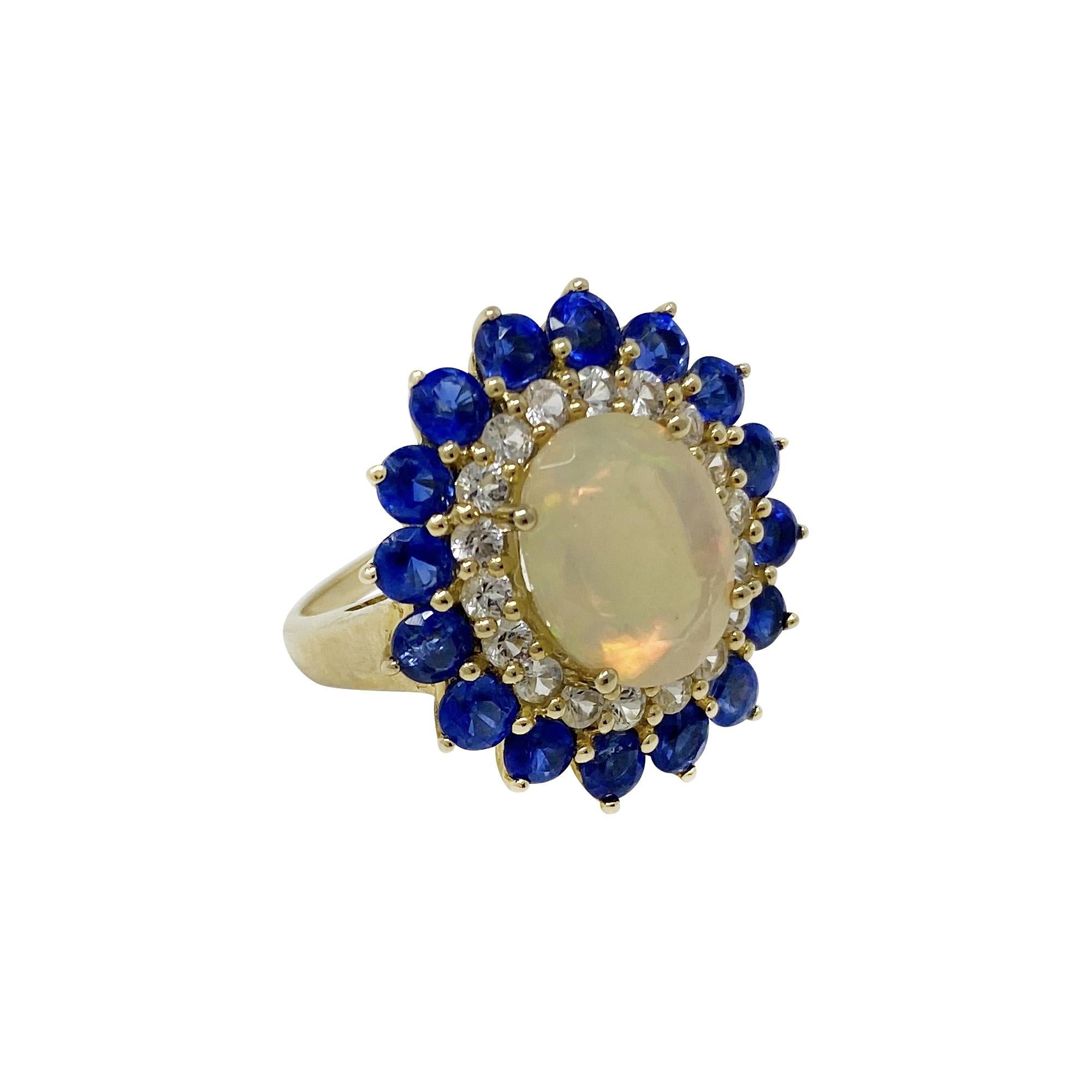 Such a big look!  These colors are stunning together!  In 14 karat yellow gold, the cabochon-cut opal is surrounded by white sapphires and kyanite.  Size 7 1/4. 