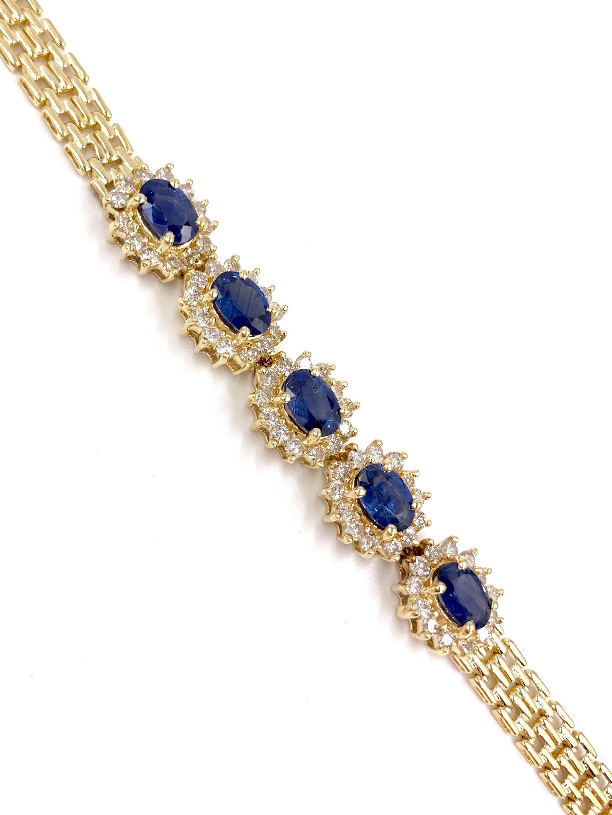 A timeless bracelet adorned with 5 beautiful, well saturated oval blue sapphires each surrounded by a halo of round brilliant diamonds stationed in the center of a 6.25mm 14 karat panthere style linked chain. Oval sapphires have an approximate total