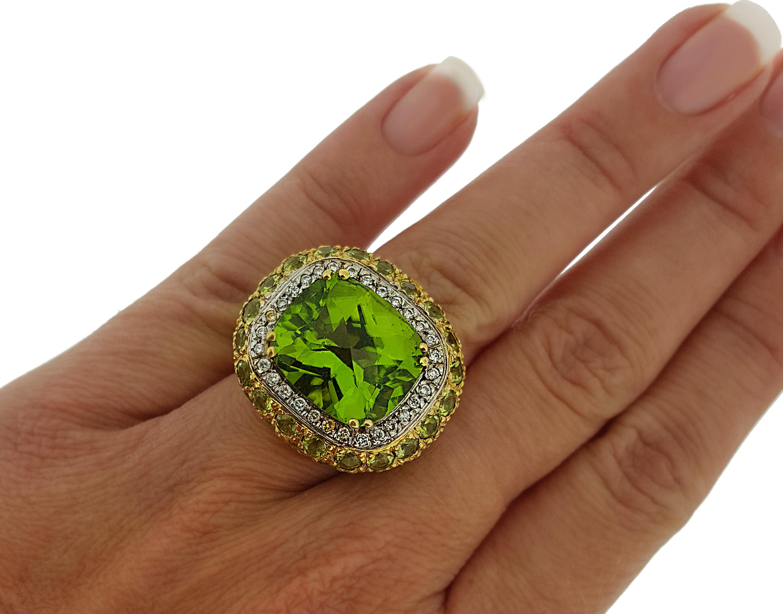 This eye catching cocktail ring showcases a vivid slightly yellowish green 20.64ct, eye-clean cushion shaped peridot perfectly framed by .30ctw of full cut round brilliant diamonds and 6.32 more carats of pave set peridot.  Set in rich 18kt yellow