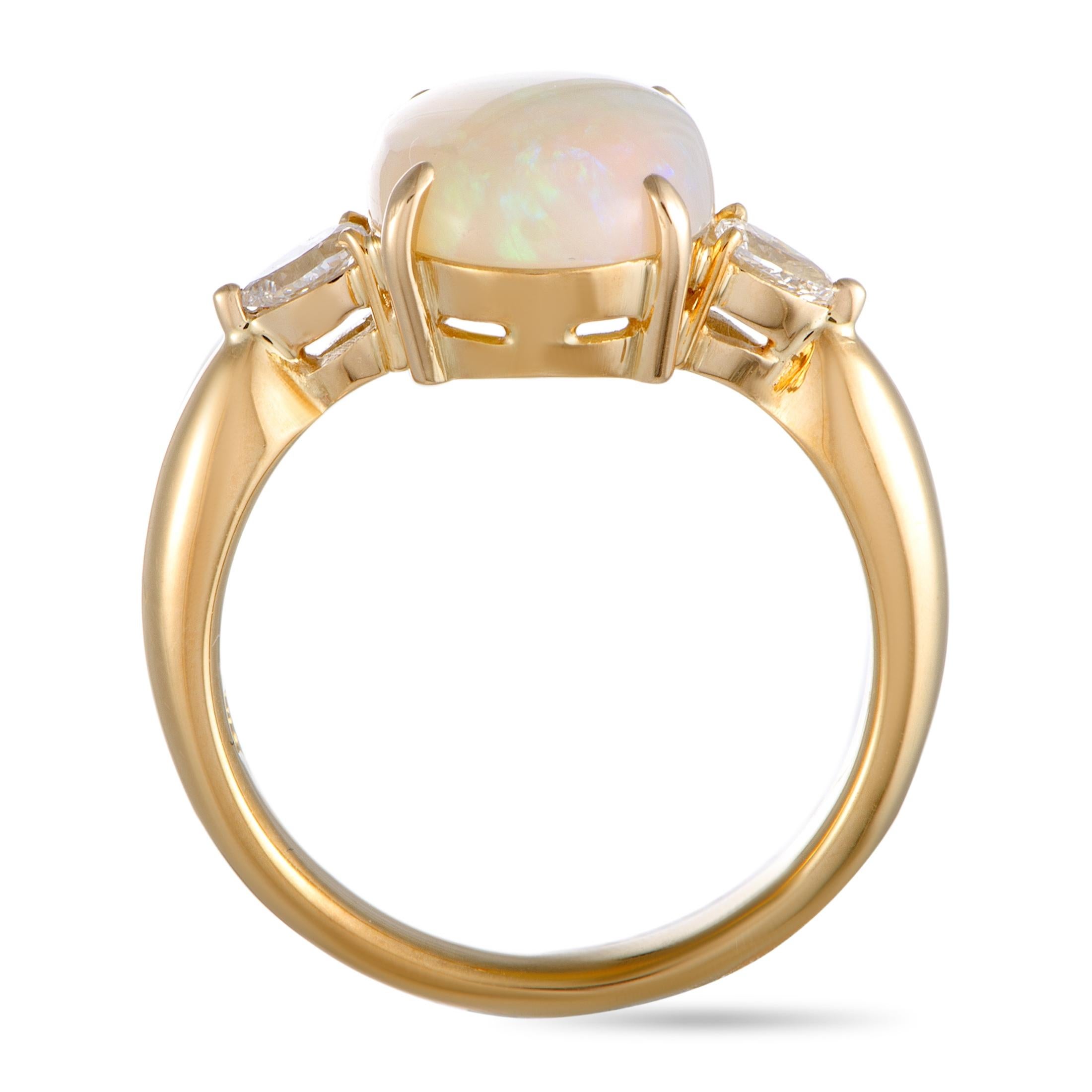 This ring is crafted from 18K yellow gold and set with an opal that weighs 3.05 carats and with pear diamonds that amount to 0.24 carats. The ring weighs 6.8 grams, boasting band thickness of 3 mm and top height of 6 mm, while top dimensions measure