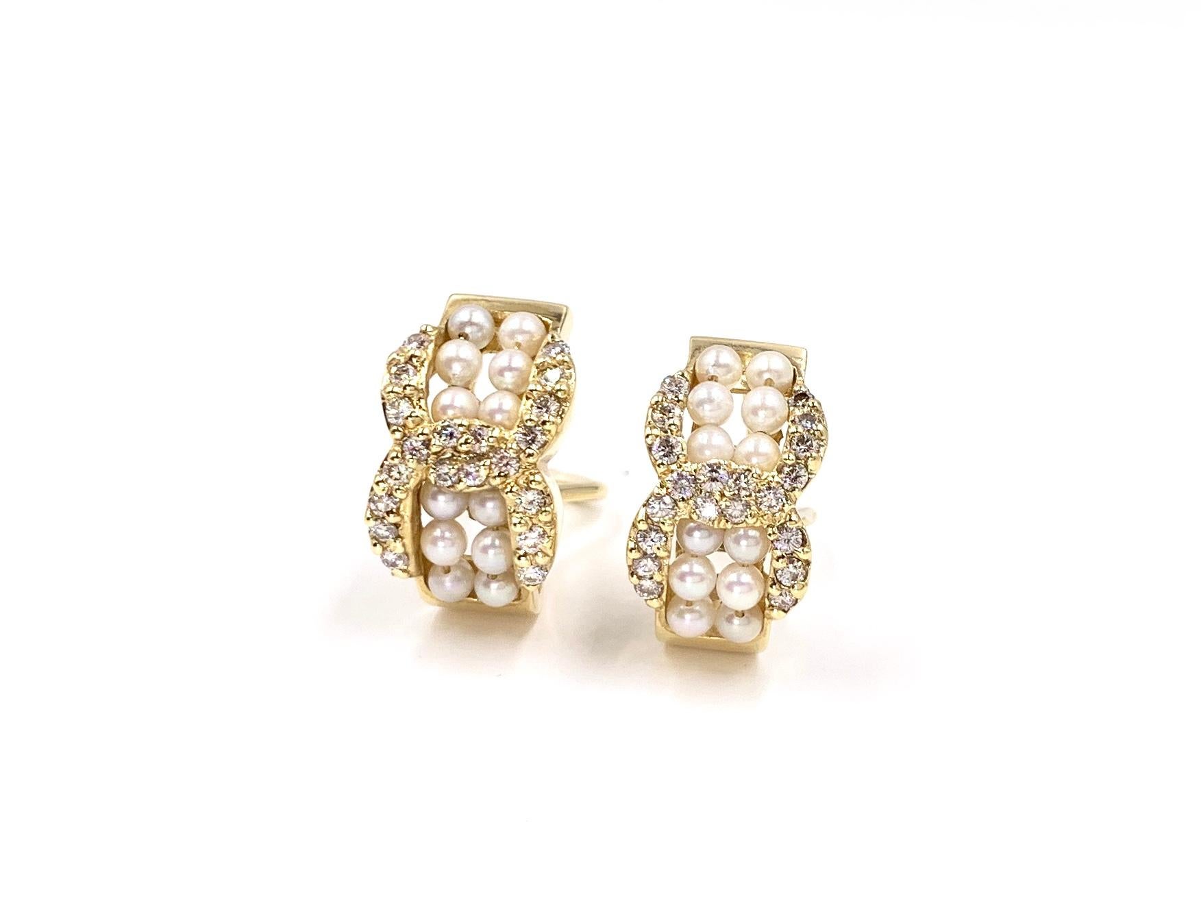 Wearable and timeless, these 14 karat yellow gold half hoop style earrings feature 14 lustrous white seed pearls in each earring with .81 carats total weight of round brilliant white diamonds, pavè set in an open link design. Earrings are fixed with