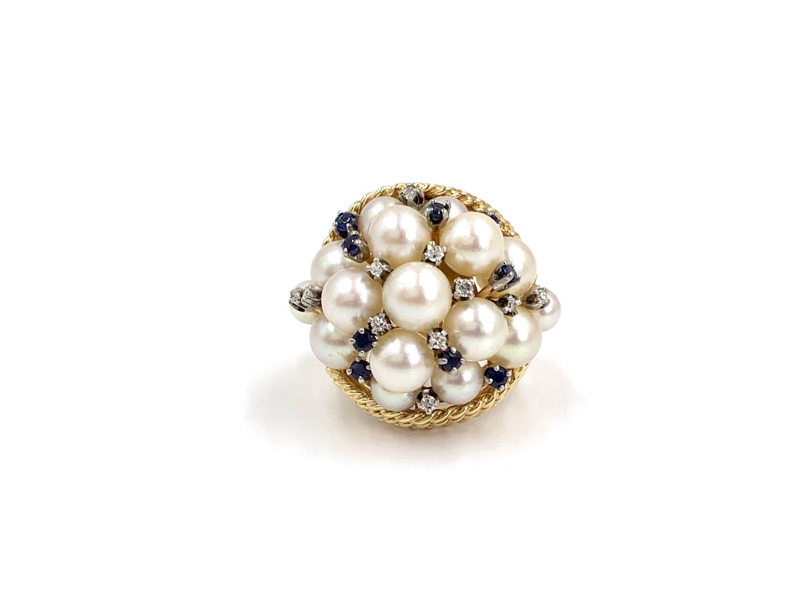 A unique statement piece made in 14 karat yellow gold featuring a domed cluster of 16 cultured round white pearls, 9 well saturated blue sapphires at approximately .20 carats total weight and 11 round diamonds at approximately .15 carats total