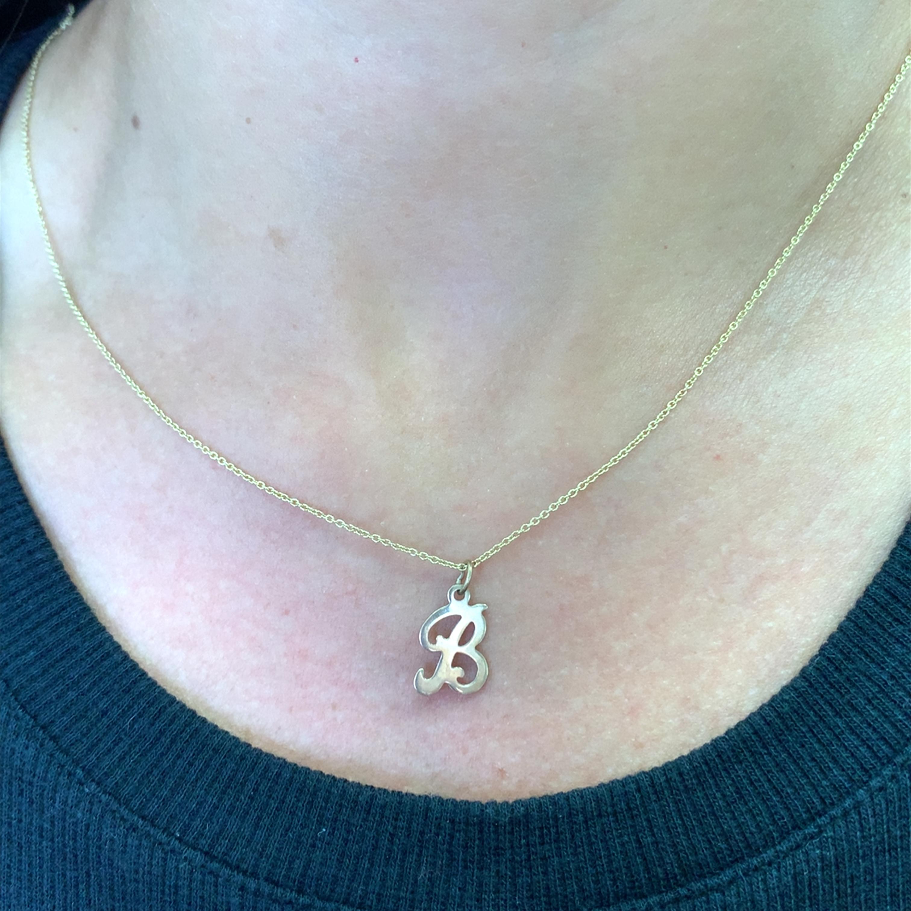 Indulge in understated elegance with this charming gold necklace, featuring a delicate chain made in 18k yellow old gold and B initial pendant made in 9ct yellow gols . Its minimalist design adds a personalized touch to any ensemble, perfect for