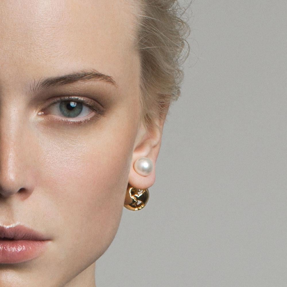 The Globe Pearl Earrings feature a double view design - a gorgeous globe with cut out world map details and a contrasting natural shell pearl that can be seen on the front of the ear.  This pair effortlessly complements any stylish and chic outfit. 