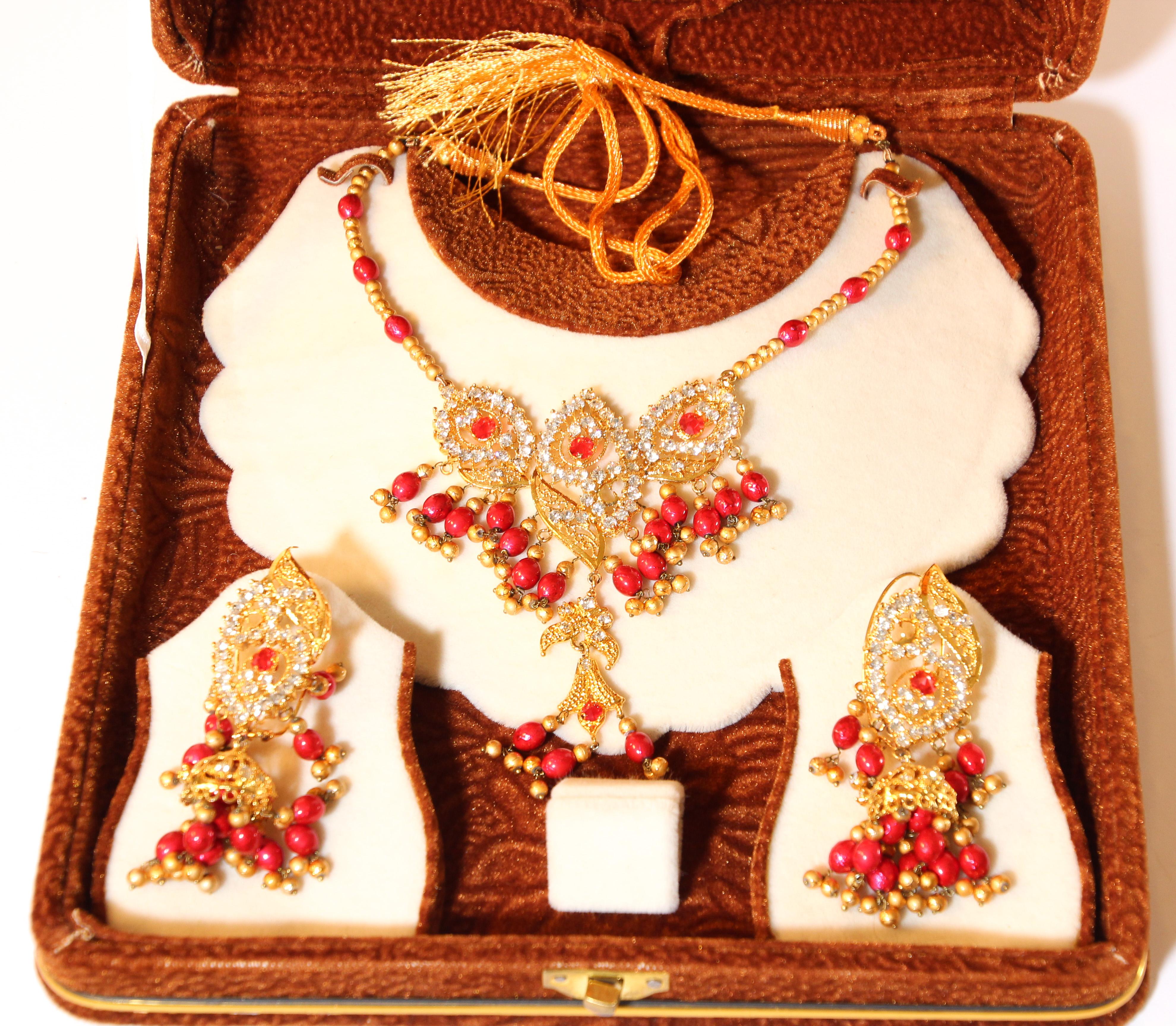 Vintage beautiful yellow gold plated India jewelry earrings and necklace set.
Vintage chocker or headpiece embellished with colorful glass beads in red.
South Indian gold plated Bollywood style jewelry bridal set.
Imperial Maharani ceremonial